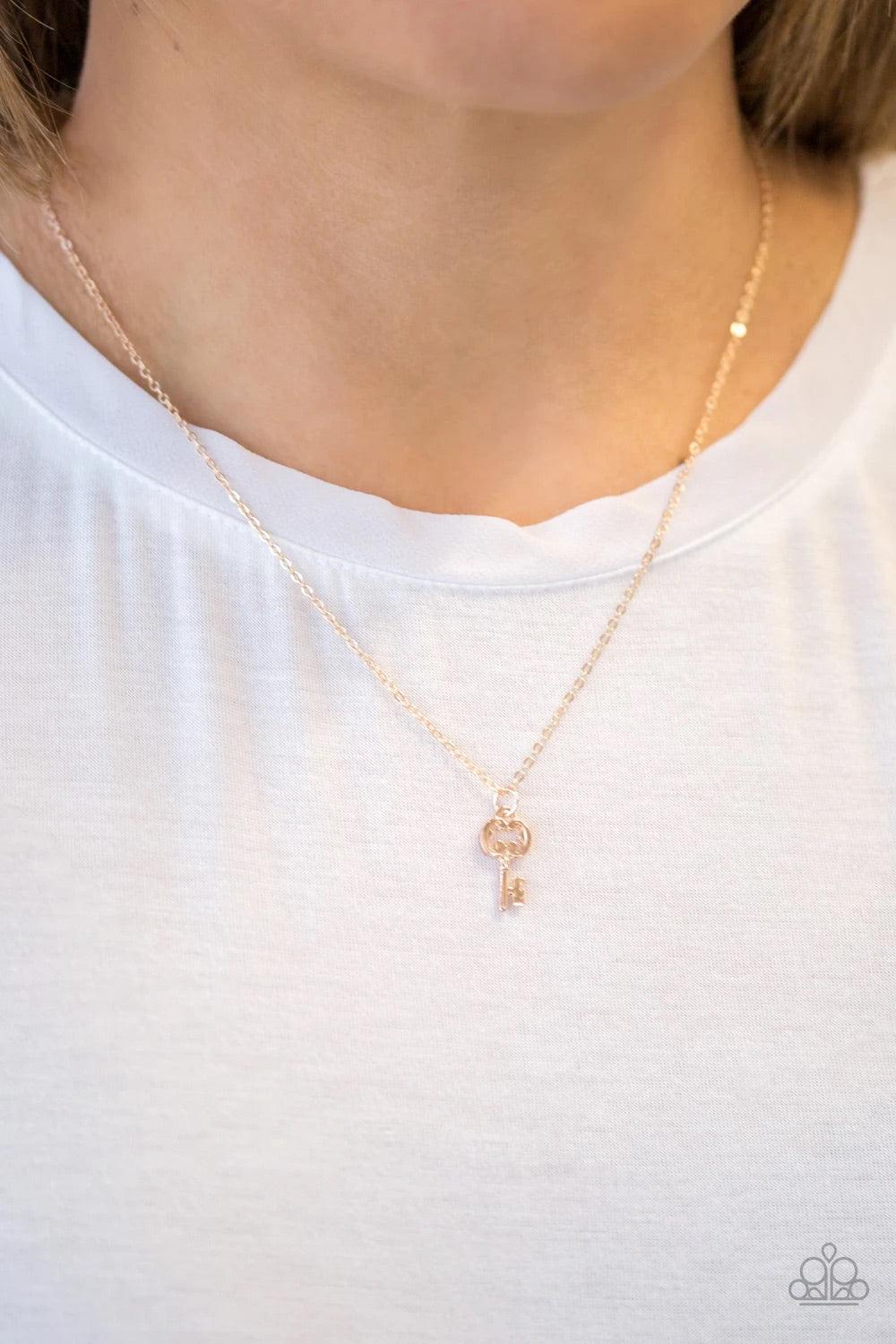 Paparazzi Accessories Very Low Key - Gold A dainty rose gold key swings from the bottom of a shiny rose gold chain, creating a whimsical pendant below the collar. Features an adjustable clasp closure. Jewelry