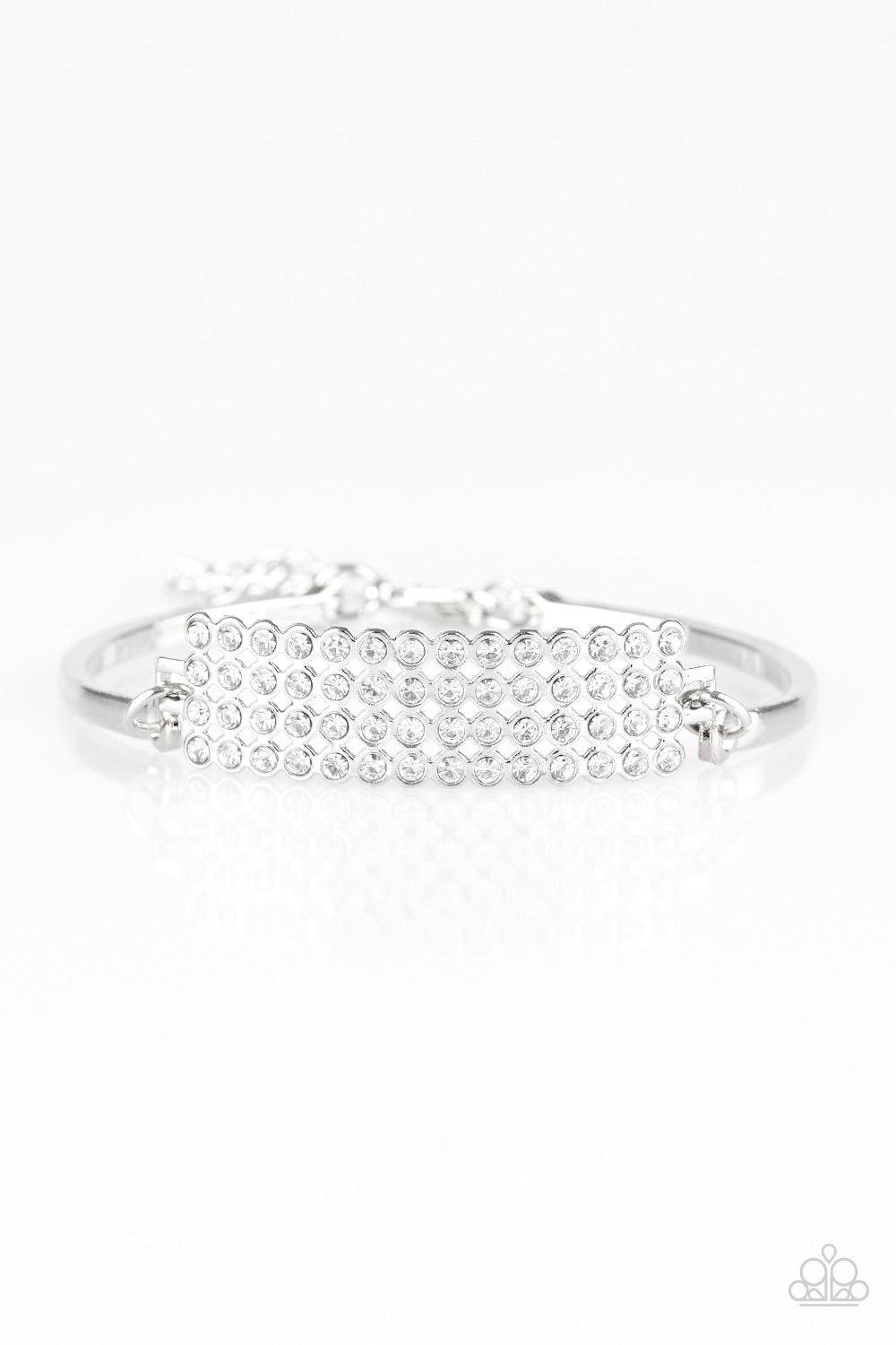 Paparazzi Accessories Top-Top Class - White Row after row of glassy white rhinestones stack into a gorgeous rectangular pendant. Attached to two arcing silver bars, the glittery pendant sits atop the wrist for an undeniably glamorous look. Features an adj