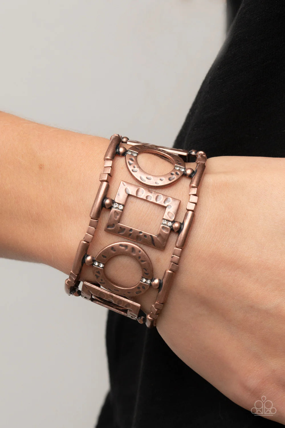 Paparazzi Accessories Framed And Fabulous - Copper Dotted with dainty white rhinestones, an airy collection of hammered circular and rectangular copper frames glides along stretchy bands around the wrist. The geometric frames are separated by trios of dai