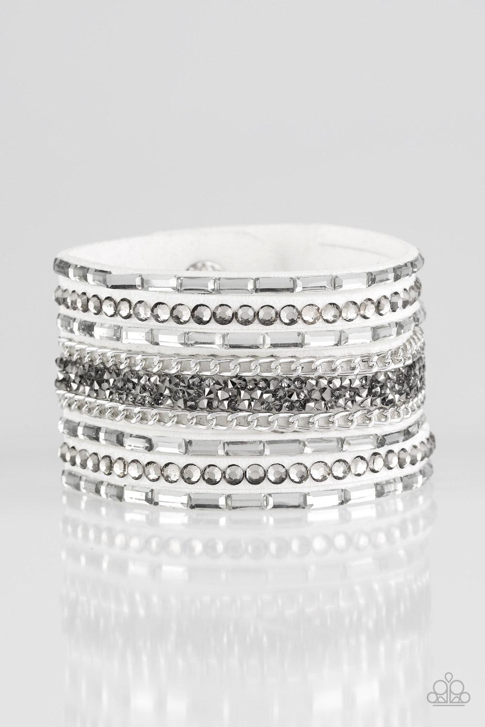 Paparazzi Accessories Rhinestone Rumble - White White emerald-cut rhinestones, smoky round rhinestones, and metallic prism-shaped rhinestones are sprinkled along strands of white suede. Shimmery silver chain is added to the mix for a sassy industrial fini