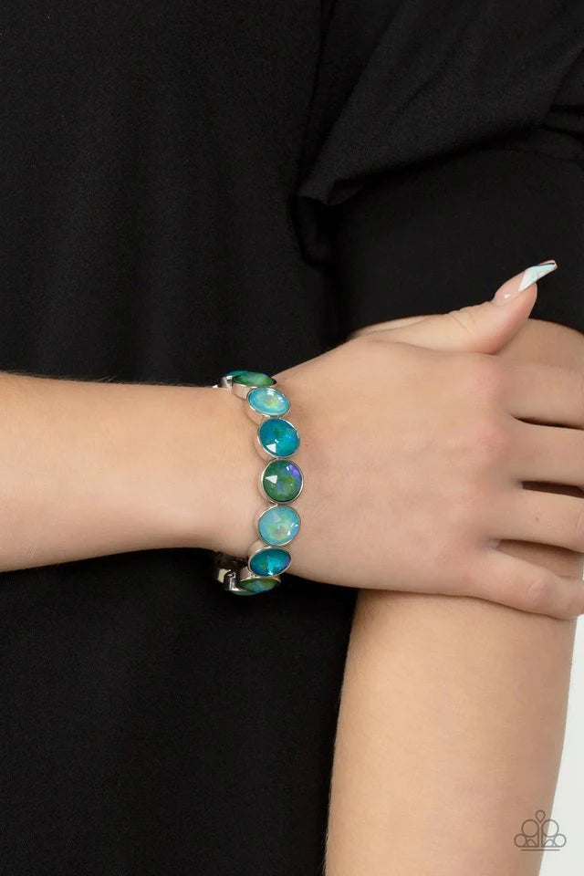 Paparazzi Accessories Radiant Repeat - Green Encased in sleek silver fittings, a sparkly series of opalescent green and blue rhinestones are threaded along stretchy bands around the wrist for a radiant finish. Sold as one individual bracelet. Jewelry