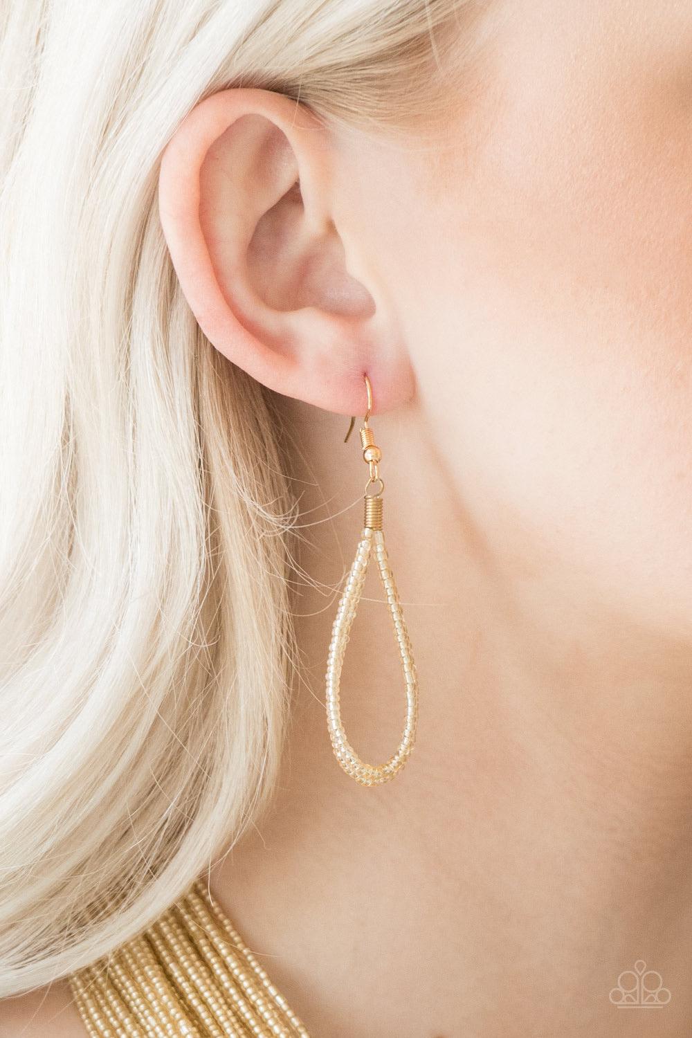 Paparazzi Accessories Streaming Starlight - Gold Brushed in a crystal-like shimmer, countless strands of gold seed beads drape across the chest in a bold fashion. Featuring a collision of shapes and shimmer, the glittery strands connect to two large gold