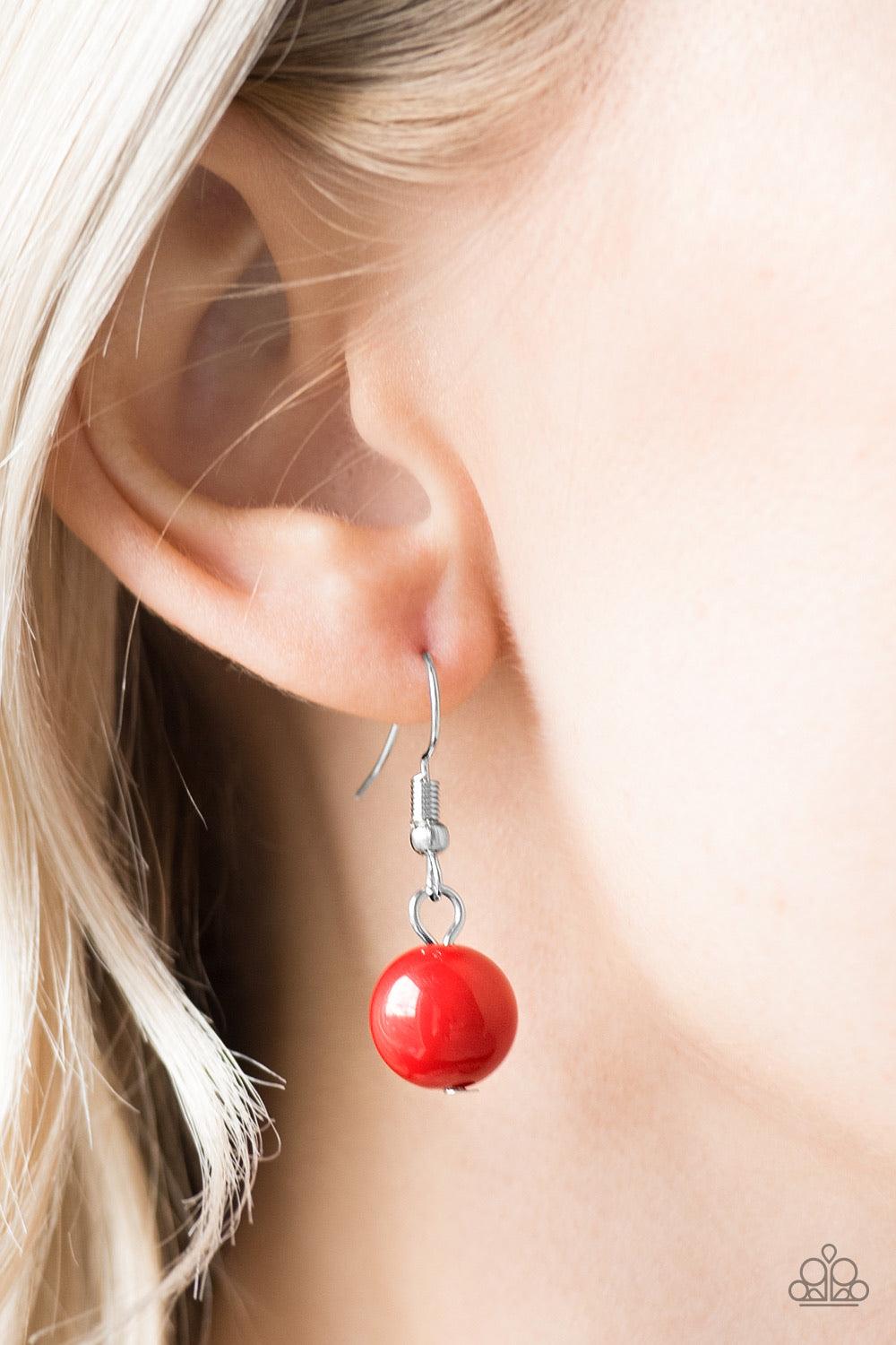 Paparazzi Accessories Brazilian Bay - Red Featuring glassy and polished finishes, round and asymmetrical red beads trickle from the bottom of a double-linked silver chain. An additional silver chain is layered above the summery beading for a seasonal fini