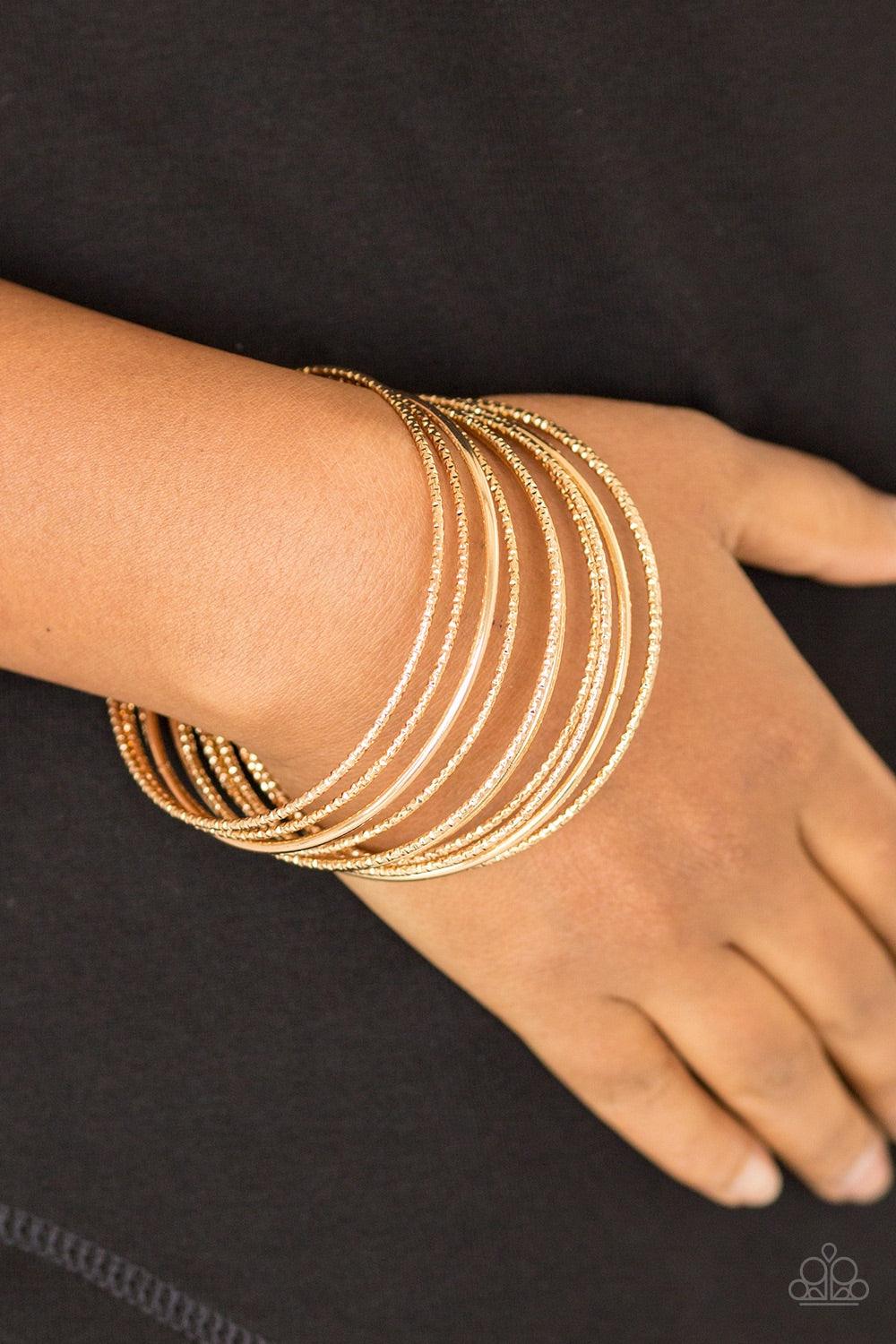 Paparazzi Accessories Bangle Babe - Gold Featuring smooth and shimmery diamond-cut textures, mismatched gold bangles stack across the wrist for a casual look. Jewelry
