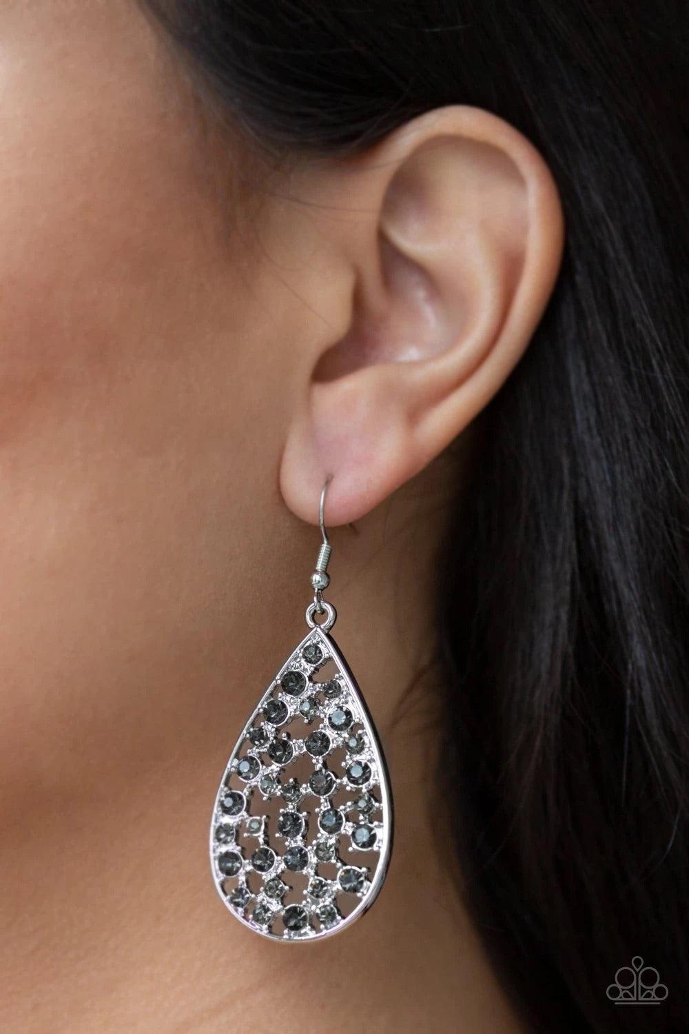 Paparazzi Accessories Call Me Universe - Silver Hints of silver frames and smoky rhinestones collect inside an airy silver teardrop, creating a gorgeous lure. Earring attaches to a standard fishhook fitting.Sold as one pair of earrings. Jewelry
