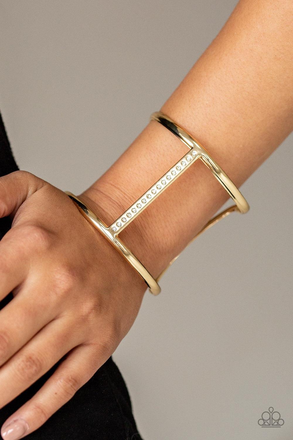 Paparazzi Accessories Diamond Deity - Gold Glassy white rhinestones are encrusted down the spine of an airy gold cuff for an edgy look. Jewelry