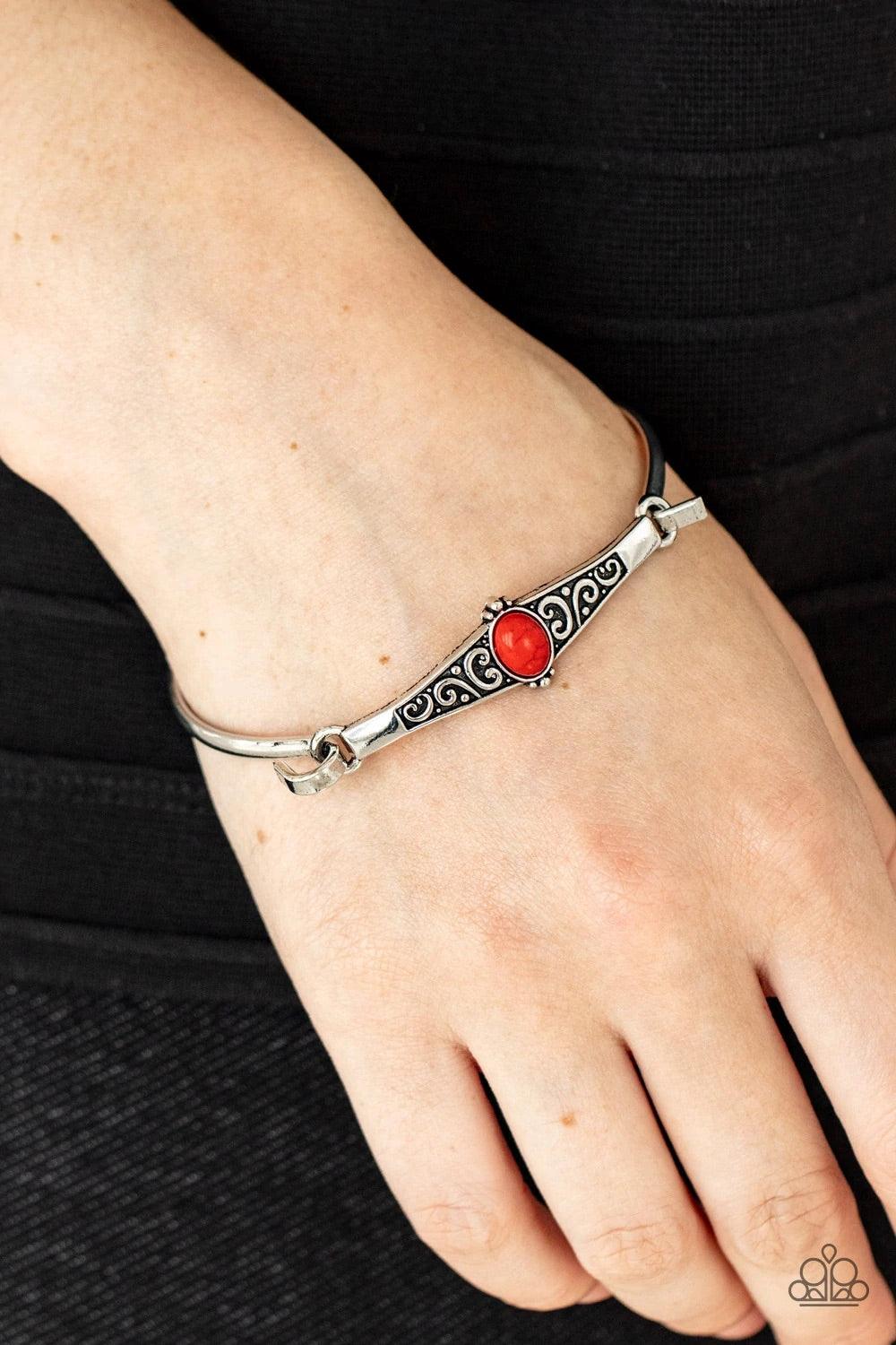Paparazzi Accessories Stone Scrolls - Red Dotted with an oval red stone, an antiqued silver frame is embossed with a vine-like scroll that hooks to a dainty cuff-like bangle, creating a whimsical centerpiece. Sold as one individual bracelet. Jewelry