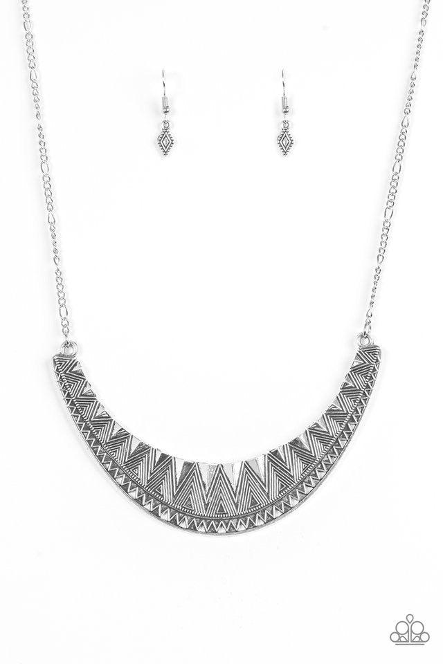 Paparazzi Accessories Thrown to The Lions - Silver Decorated in shimmery geometric detail, a glistening silver crescent swings below the collar, creating a bold tribal pendant. Features an adjustable clasp closure. Sold as one individual necklace. Include