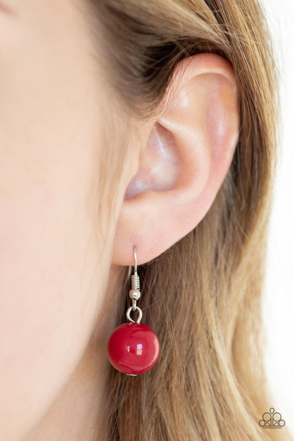 Paparazzi Accessories Weekend Party ~Red A collection of oversized silver beads, robust Samba beads, white rhinestone encrusted rings, and metallic crystal-like beads are threaded along an invisible wire below the collar for a glamorous statement-making f