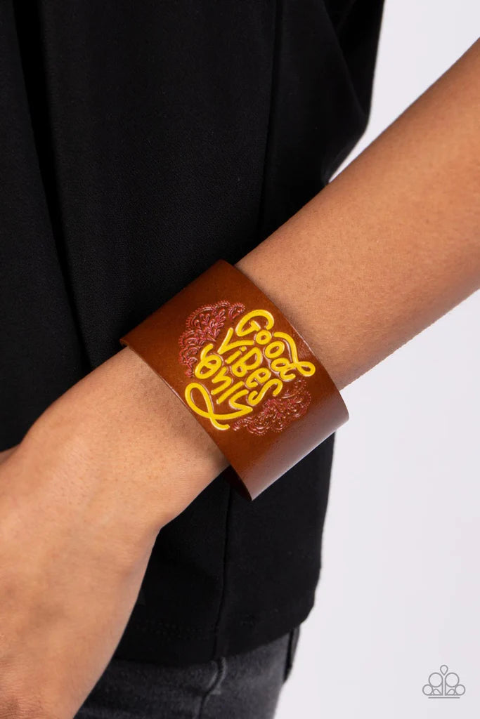 Paparazzi Accessories Easy Energy - Yellow A thick band of brown leather is stamped with the upbeat message, Good Vibes Only, in a vibrant shade of Primrose Yellow. Vine-like patterns bloom around the curling font, creating a paisley pattern tinted in pin