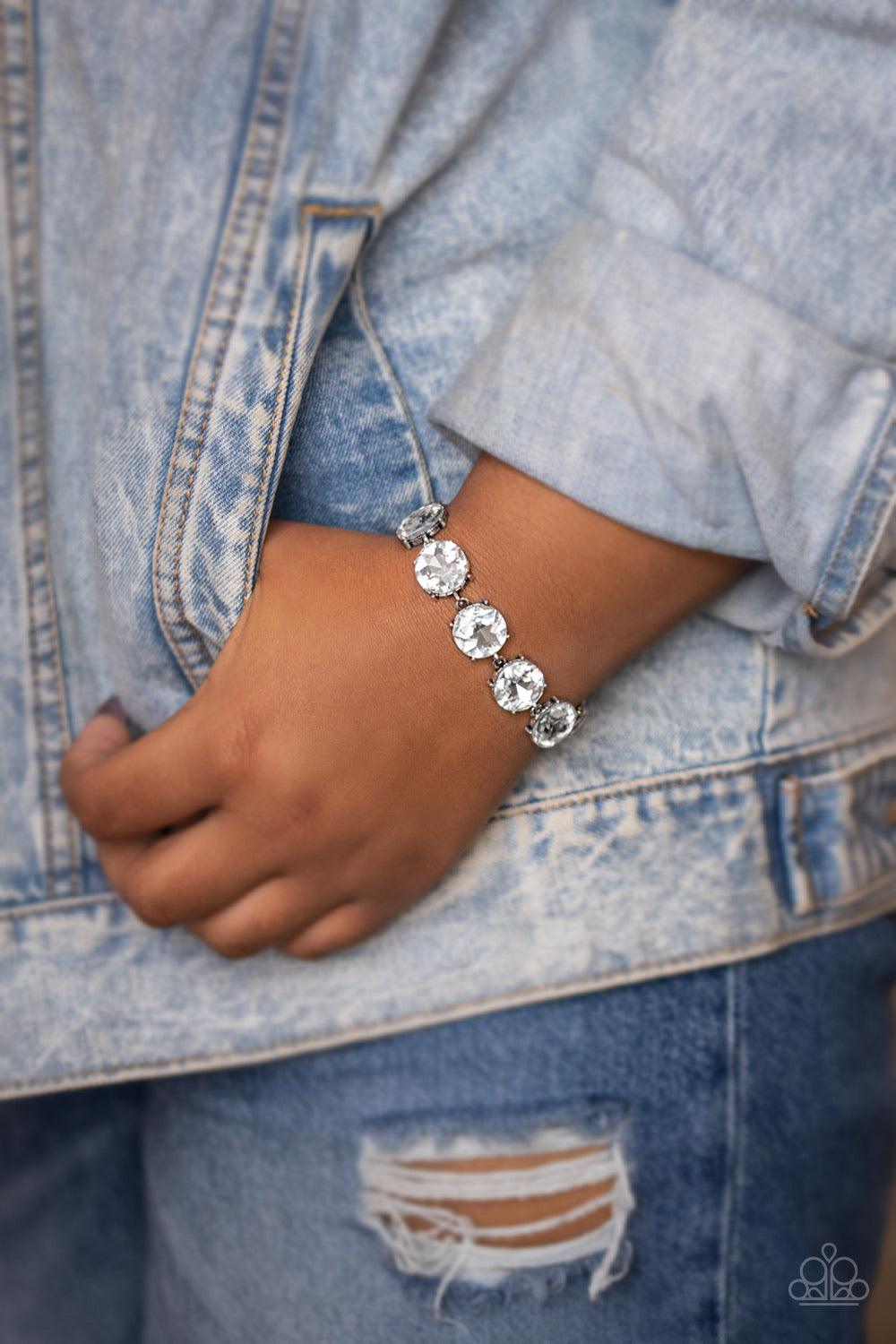 Paparazzi Accessories Fabulously Flashy - White Nestled inside classic silver fittings, a collection of oversized white rhinestones delicately link around the wrist for a flashy finish. Features an adjustable clasp closure. Sold as one individual bracelet