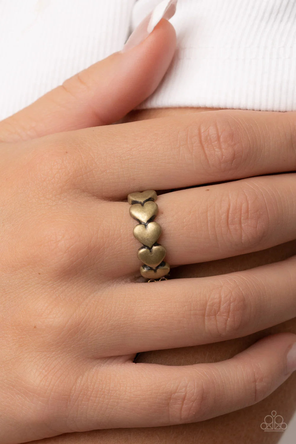 Paparazzi Accessories Rhythm of Love - Brass Brushed in an antiqued shimmer, a dainty row of brass heart frames repeats across the finger for a rustically romantic flair. Features a dainty stretchy band for a flexible fit. Jewelry