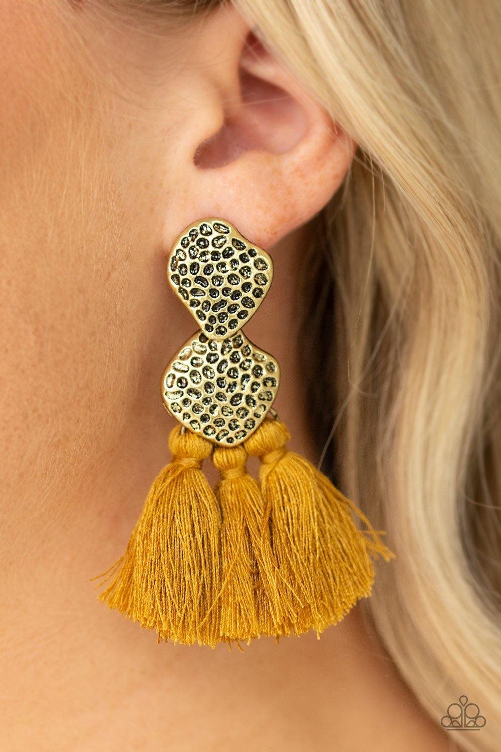 Paparazzi Accessories Tenacious Tassel - Yellow Delicately hammered in glistening textures, two asymmetrical brass frames link into an abstract lure. Three yellow threaded tassels swing from the bottom of the rustic frame for a trendy finish. Earring atta