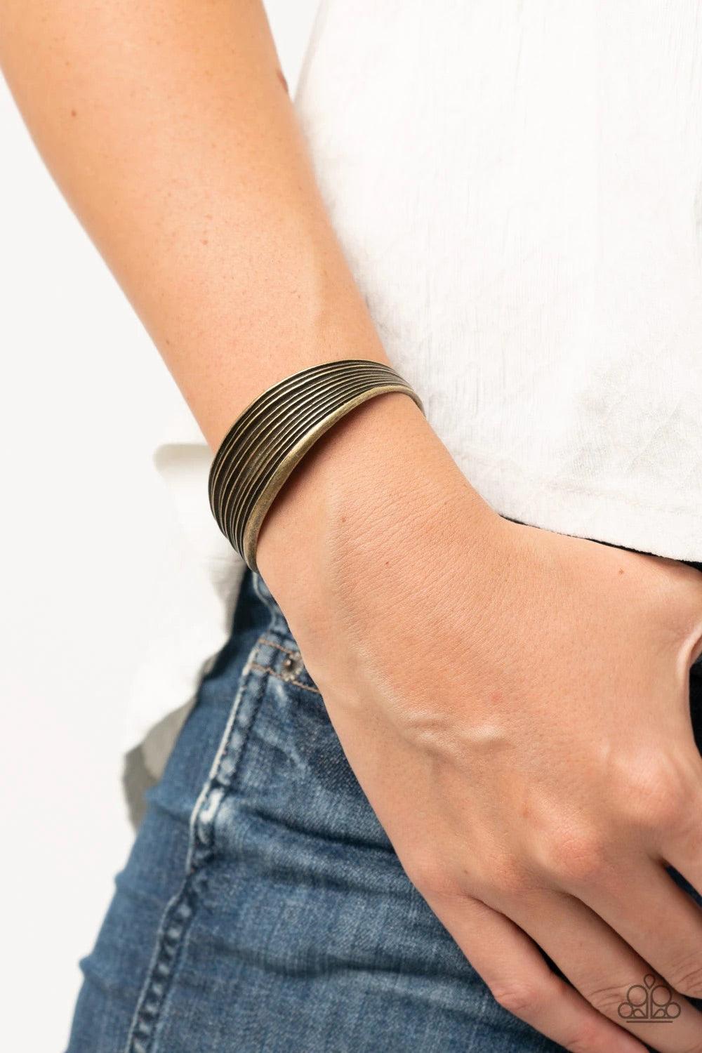 Paparazzi Accessories Off The Cuff Couture - Brass Featuring beveled linear texture, a thick brass cuff delicately curls around the wrist for a dash of rustic refinement. Sold as one individual bracelet. Jewelry