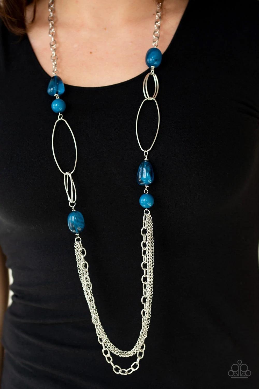 Paparazzi Accessories Pleasant Promenade - Blue Featuring polished and cloudy faux rock finishes, blue beads link with bold silver hoops. The whimsical compilation gives way to layers of mismatched silver chains for a seasonal finish. Features an adjustab