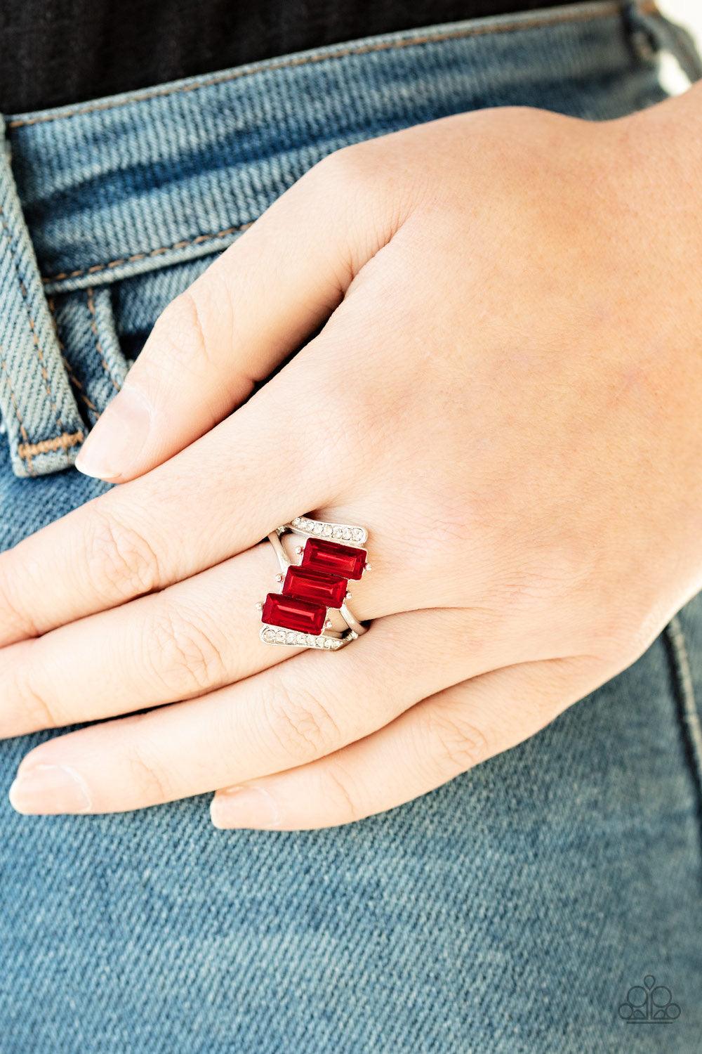 Paparazzi Accessories Triple Razzle ~Red Nestled between two dazzling white rhinestone encrusted silver fittings, three emerald cut red rhinestone slant across the finger for a glamorous look. Features a dainty stretchy band for a flexible fit.