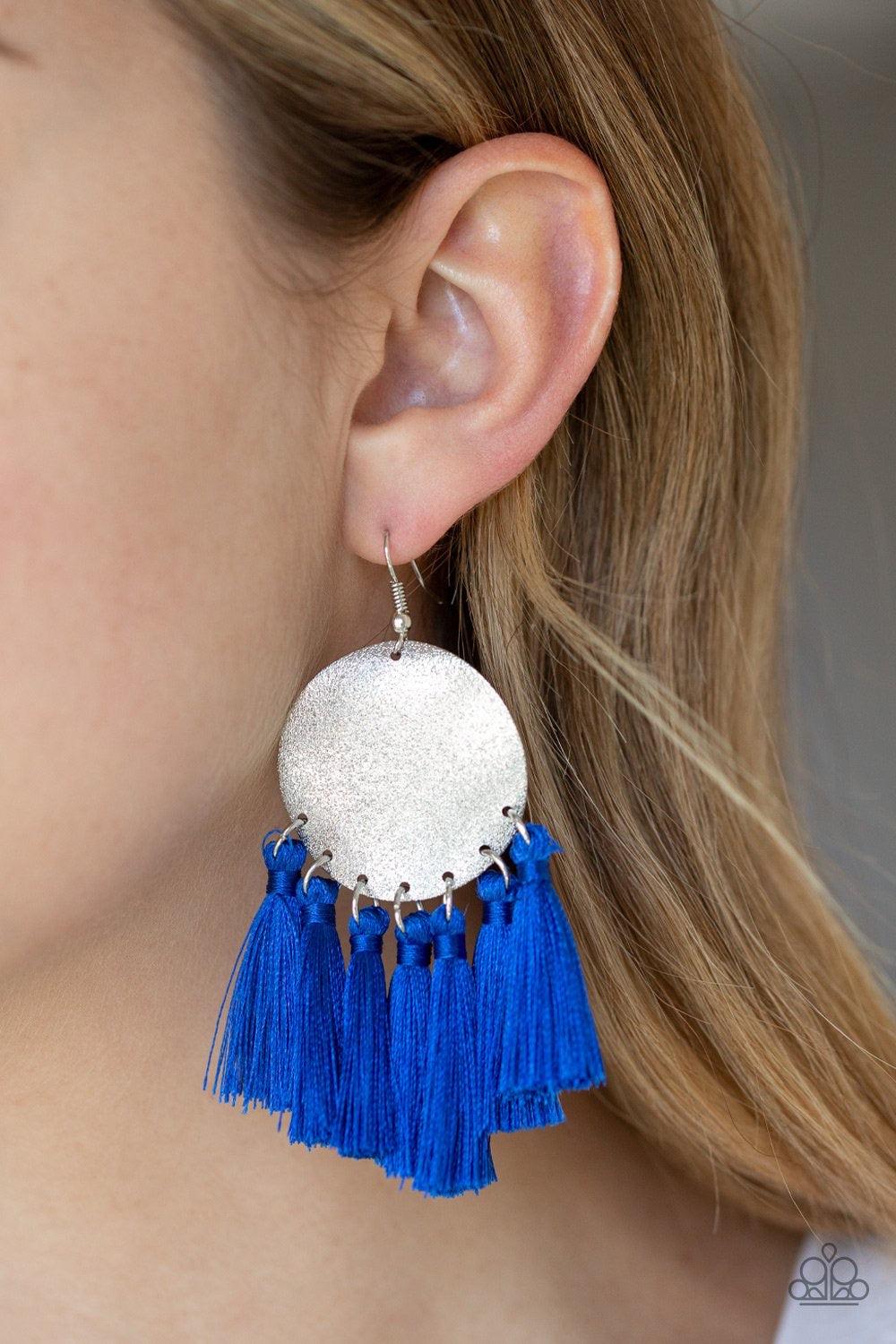 Paparazzi Accessories Tassel Tribute - Blue A fringe of shiny Galaxy Blue threaded tassels swing from the bottom of a warped silver disc brushed in an incandescent metallic shimmer for a whimsical flair. Earring attaches to a standard fishhook fitting. Je