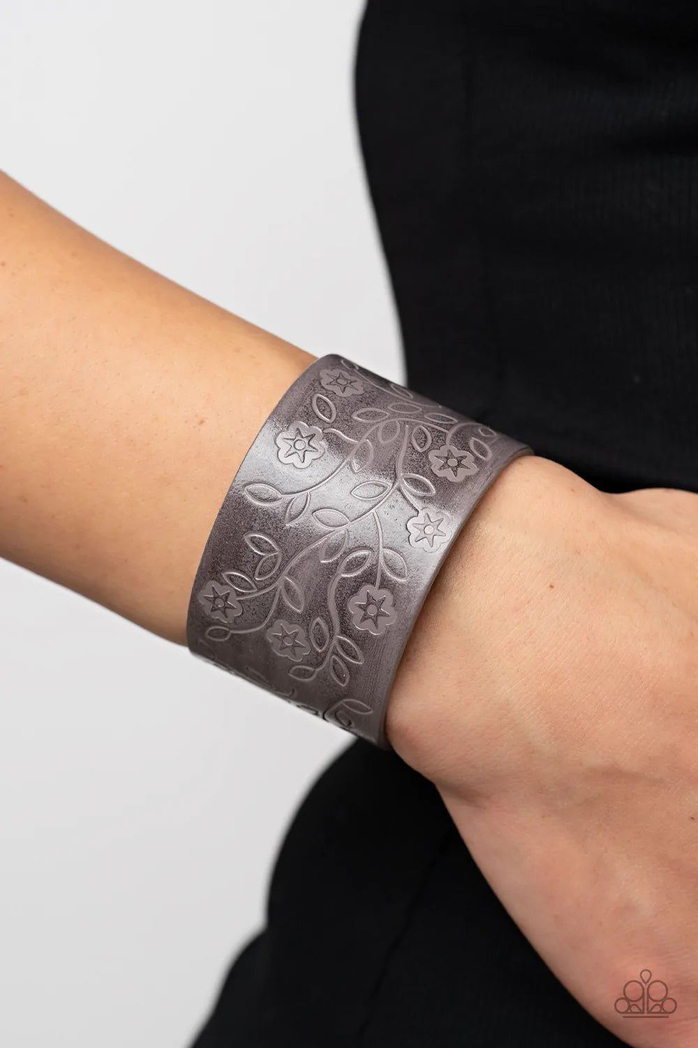 Paparazzi Accessories Rosy Wrap Up - Silver A flowery and leafy motif blooms across the front of a distressed gray leather band, resulting in a rustic floral centerpiece around the wrist. Features an adjustable snap closure. Sold as one individual bracele