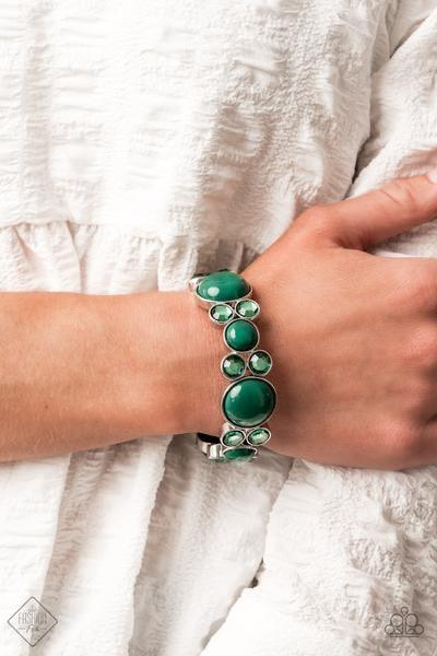 Paparazzi Accessories Celestial Escape - Green Infused with pairs of Ultramarine Green rhinestones, mismatched Ultramarine Green beaded silver frames are delicately threaded along stretchy bands around the wrist for a whimsical pop of color. Sold as one i