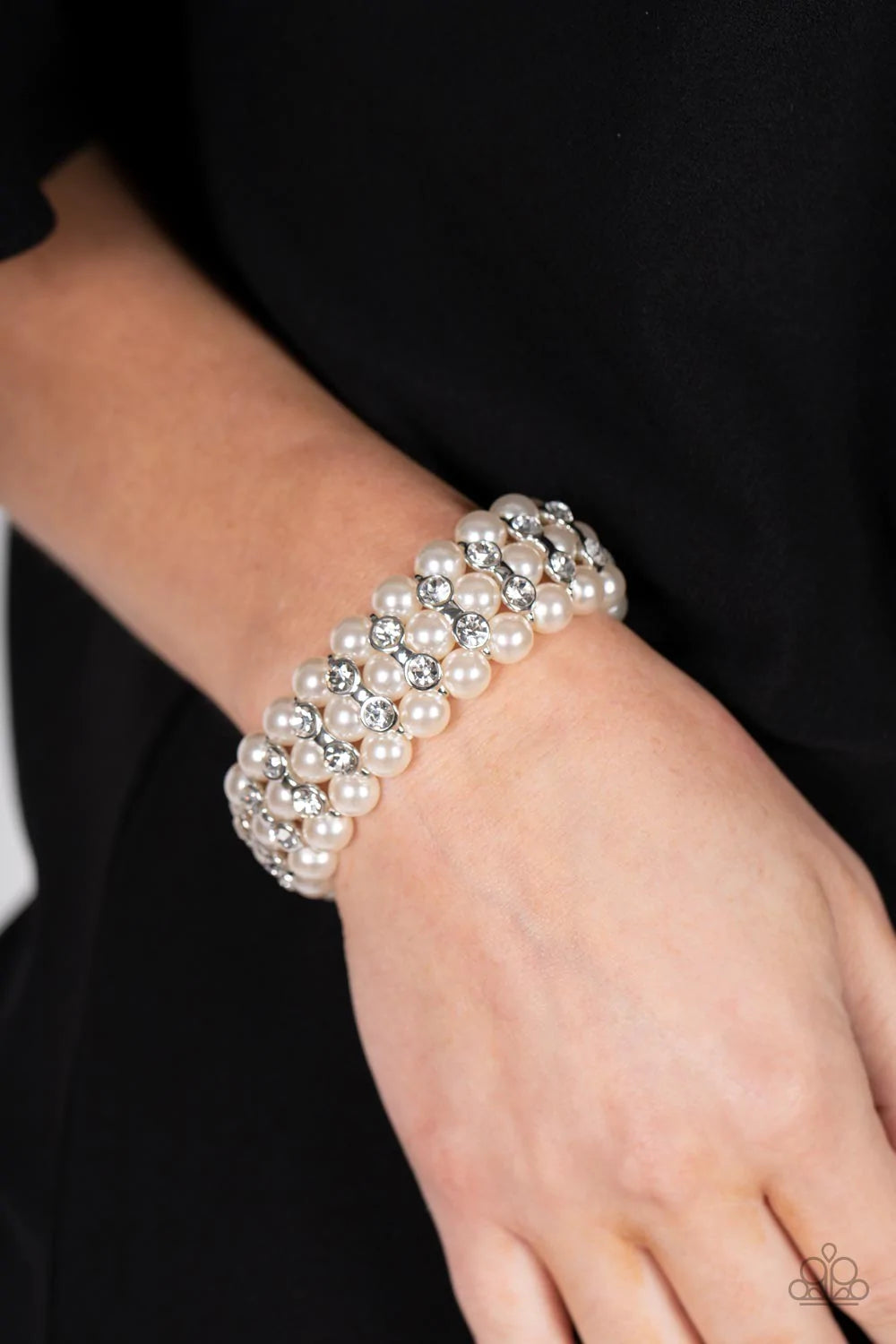Paparazzi Accessories Eiffel Tower Elegance - White Stacked rows of bubbly white pearls alternate with white rhinestone encrusted silver frames along stretchy bands, adding a timeless twist to the traditional pearl palette. Sold as one individual bracelet