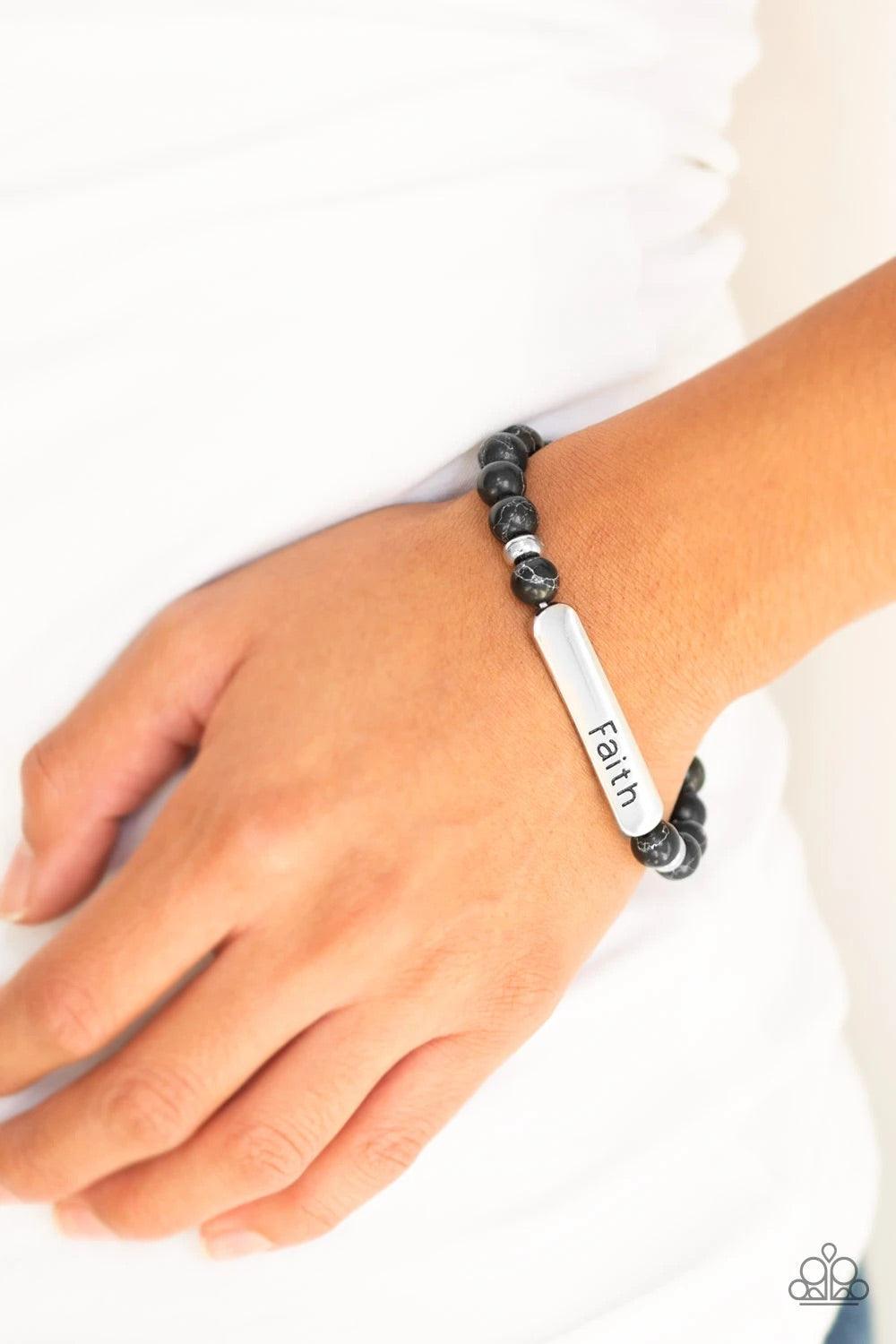 Paparazzi Accessories Fearless Faith - Black Infused with dainty silver beads, earthy black stone beads and a glistening silver plate stamped in the word, "Faith", are threaded along a stretchy band for a seasonal look. Sold as one individual bracelet. Je