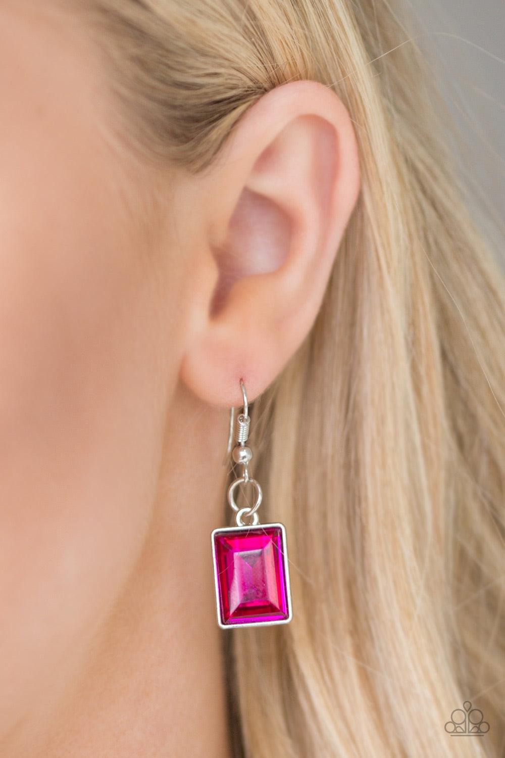 Paparazzi Accessories Wear It Like You Mean It! - Pink Featuring a regal emerald-style cut, a glassy pink rhinestone is pressed into a sleek silver frame. The glittery frame swings from the bottom of a bold silver chain, creating a glamorous pendant below