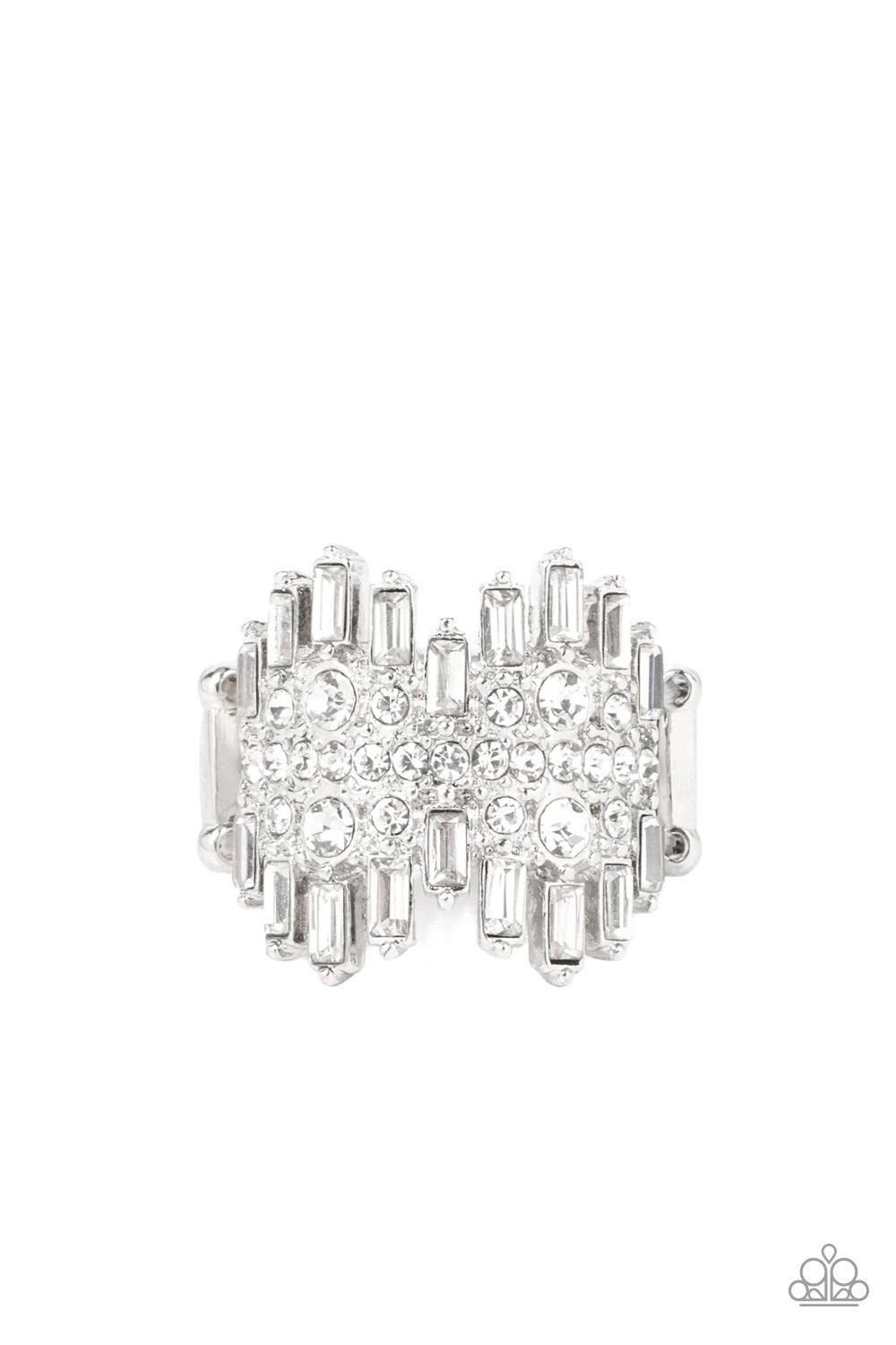 Paparazzi Accessories Urban Empire - White Staggered rows of emerald cut rhinestones flare out from the top and bottom of an explosion of classic white rhinestones, creating a smoldering statement piece atop the finger. Features a stretchy band for a flex