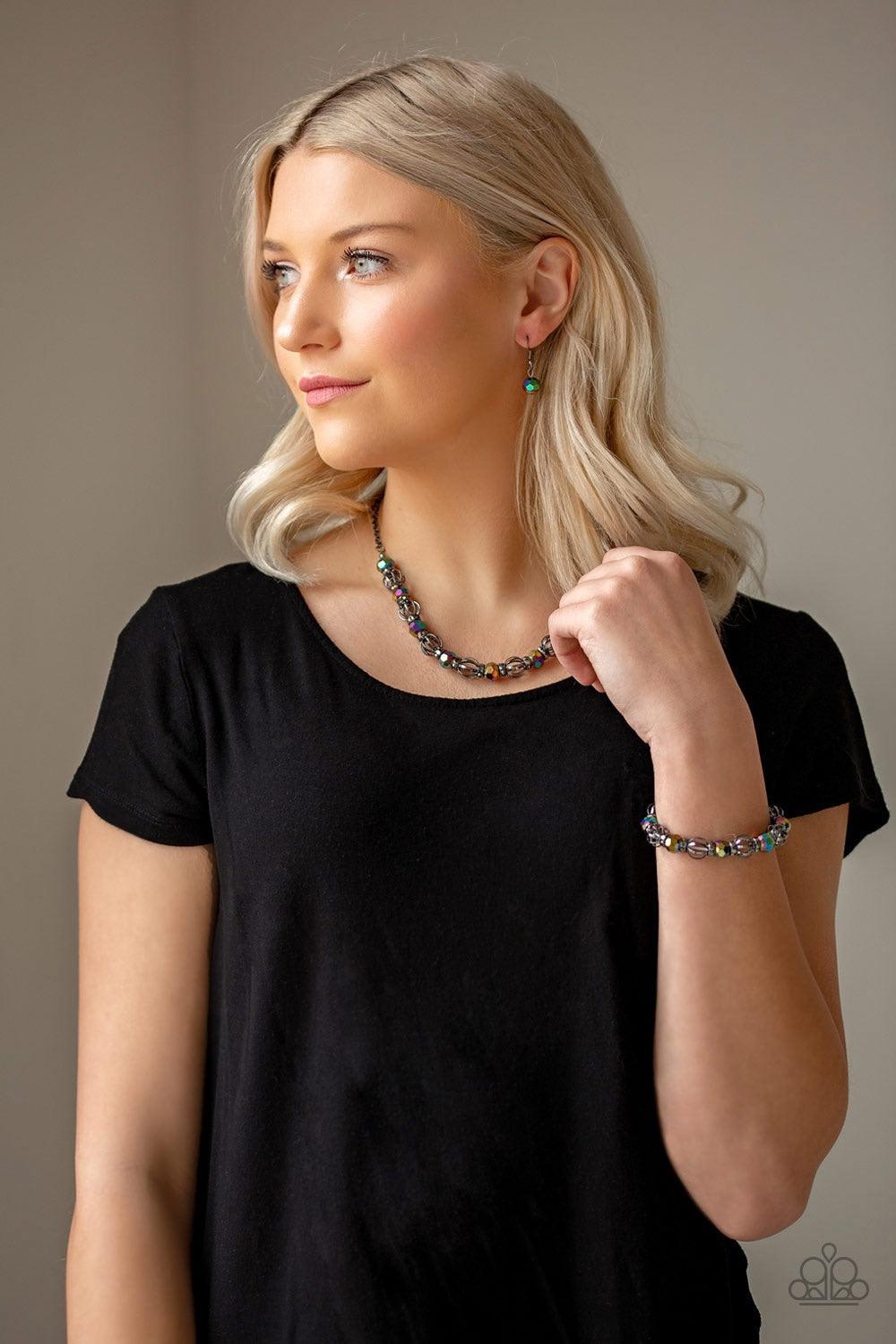 Paparazzi Accessories Metro Majestic - Multi A collection of airy gunmetal beads, faceted rainbow metallic beads, and hematite rhinestone encrusted rings are threaded along an invisible wire below the collar for a statement-making fashion. Features an adj