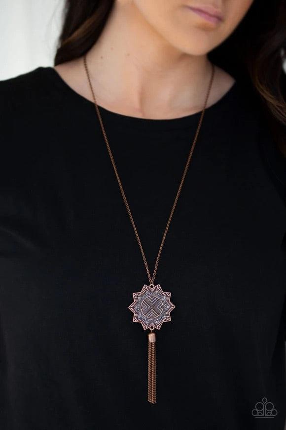Paparazzi Accessories From Sunup To Sundown - Copper A textured sunburst pendant swings from the bottom of a lengthened copper chain. A shimmery copper chain tassel swings from the bottom of the tribal inspired pendant for a seasonal finish. Features an a