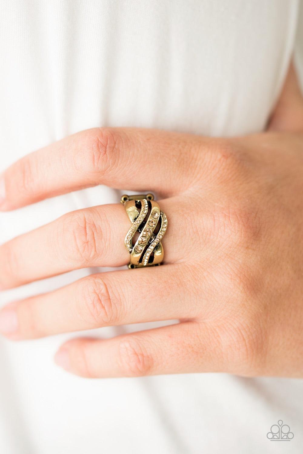 Paparazzi Accessories Flirting with Sparkle - Brass Shimmery brass bars swoop across the finger, creating an airy band. Complemented with dainty topaz rhinestones, the centermost brass band is encrusted in slightly larger glittery topaz rhinestones for a