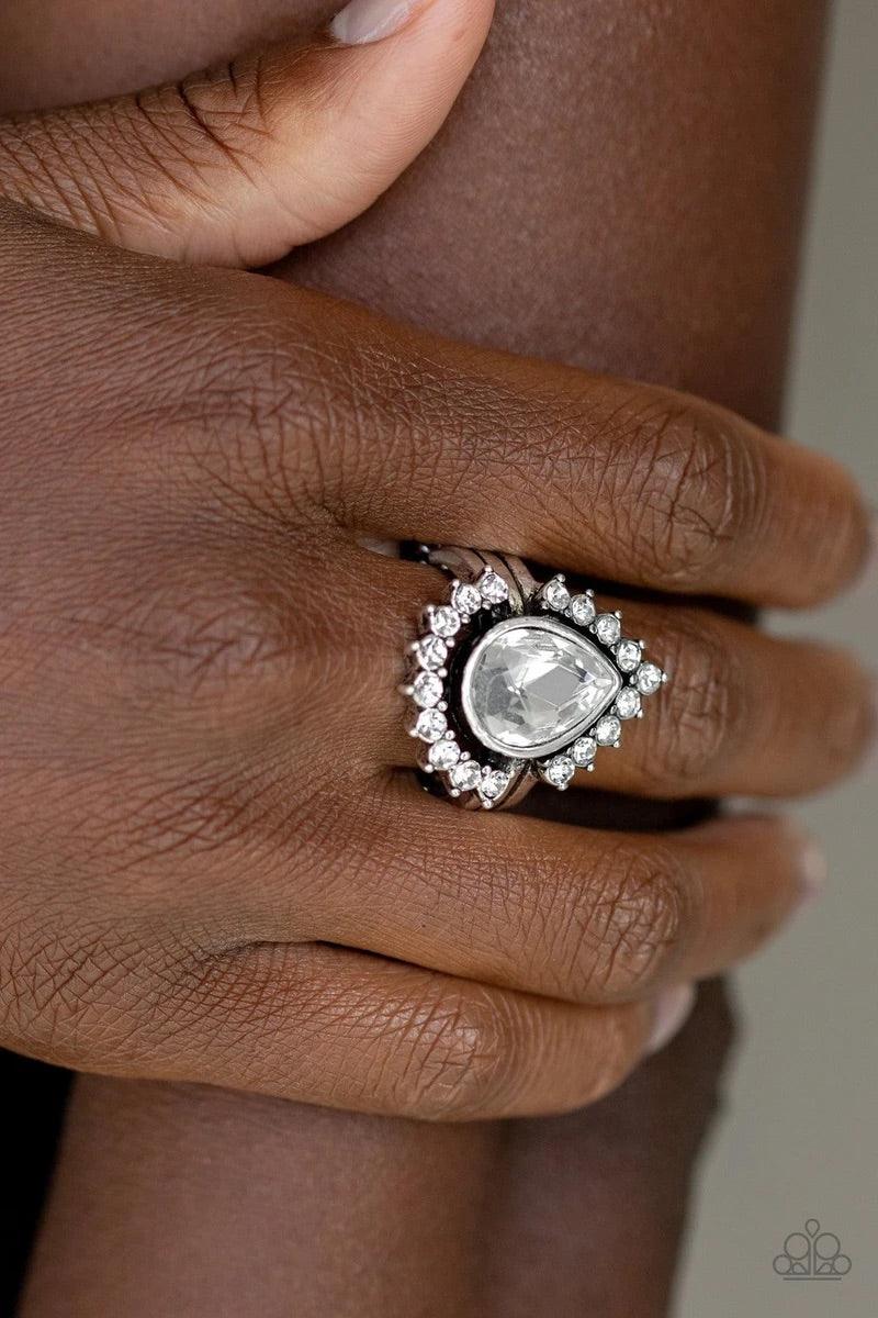 Paparazzi Accessories Make Your TRADEMARK - White A ring of glittery white rhinestones fans out from a dramatically oversized white teardrop rhinestone center, creating the illusion of a floating centerpiece. Features a stretchy band for a flexible fit.So