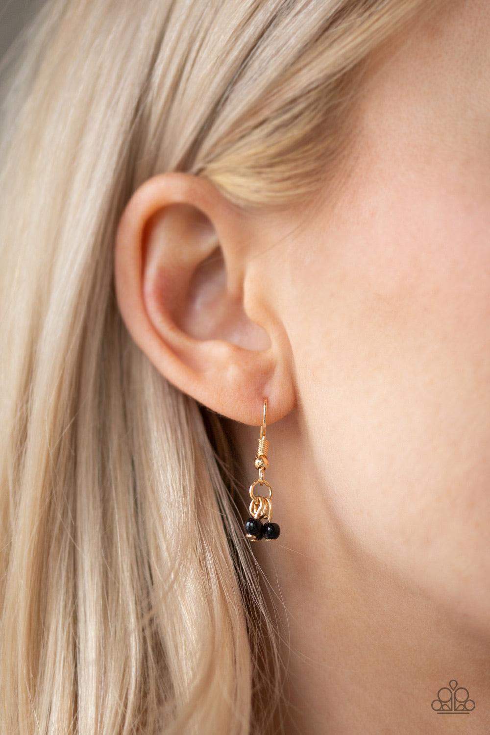 Paparazzi Accessories Boho Baby - Gold Embossed in tribal inspired patterns, gold half-moon frames link below the collar. Dainty black beads swing from the bottoms of the ornate frames, creating a flirtatious fringe. Features an adjustable clasp closure.