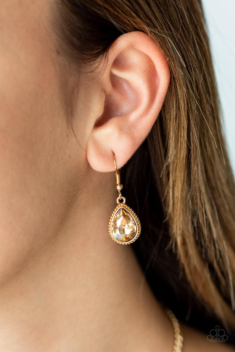 Paparazzi Accessories Socialite Social - Gold Featuring ornate gold frames, golden teardrop gems link below the collar in a timeless fashion. The largest teardrop swings from the center, creating a glamorous pendant. Features an adjustable clasp closure.