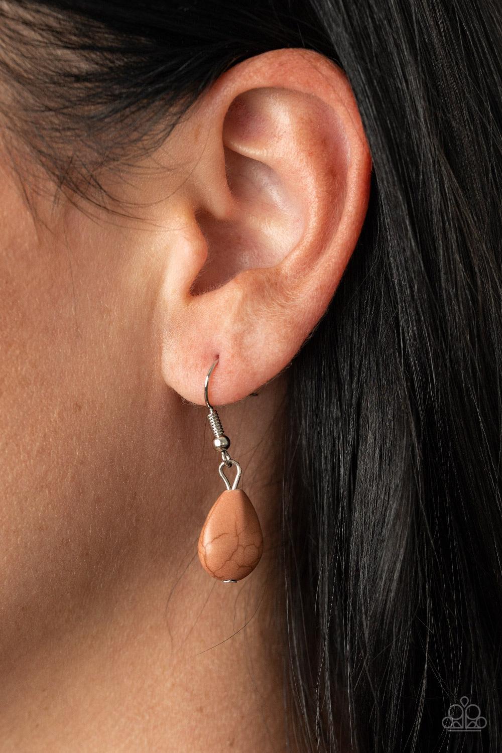 Paparazzi Accessories Rural Rapture - Brown Linked by handcrafted fittings, a pair of imperfect brown stones are pressed into asymmetrical hammered silver frames as they stack below the collar. Oversized silver links and a pair of hammered links form into
