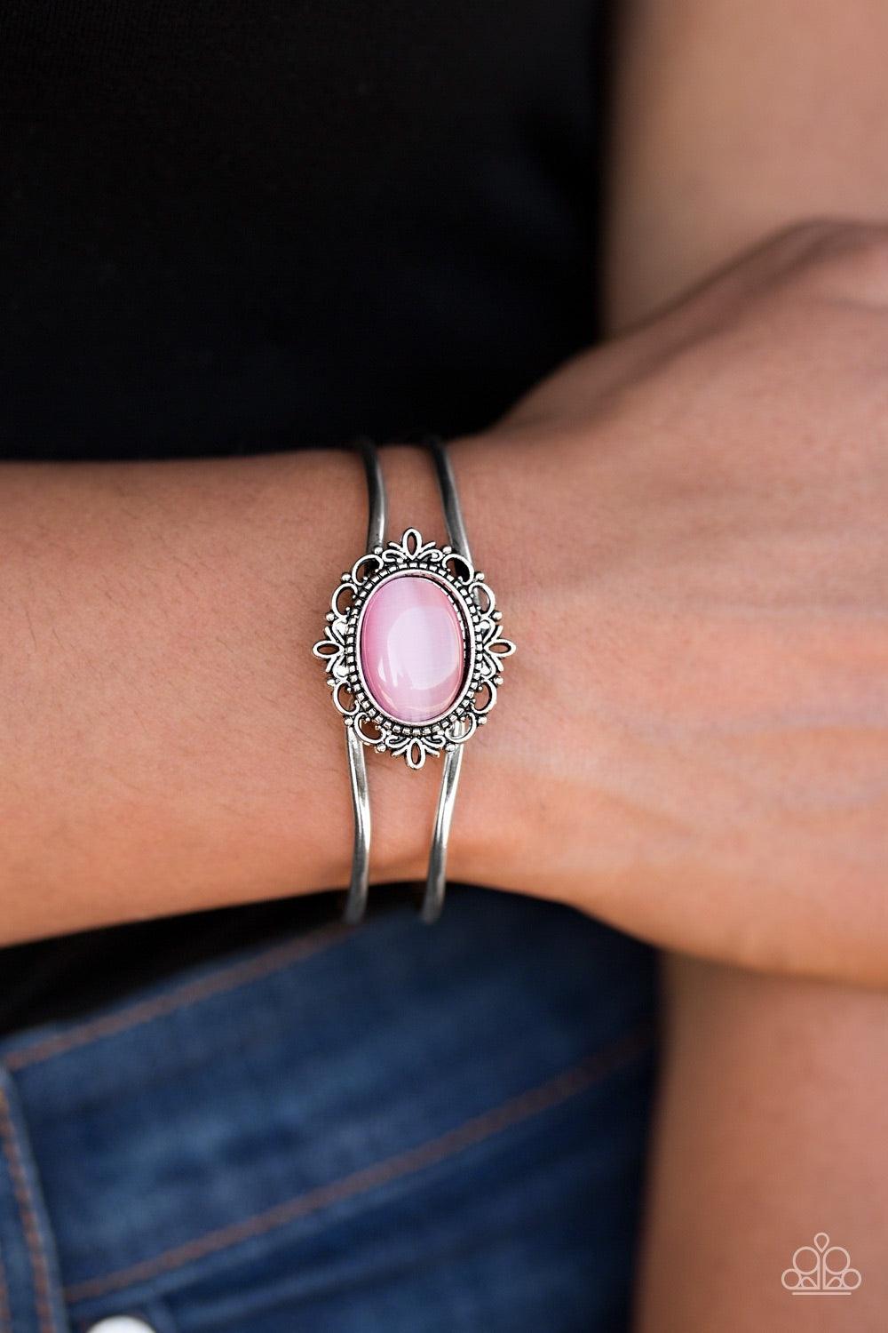 Paparazzi Accessories Castles And Champions - Pink A glassy pink moonstone is pressed into a frilly silver frame, creating a whimsical center piece. The bangle-like bars curl around the wrist, creating an airy piece. Features an adjustable hinged clasp. J