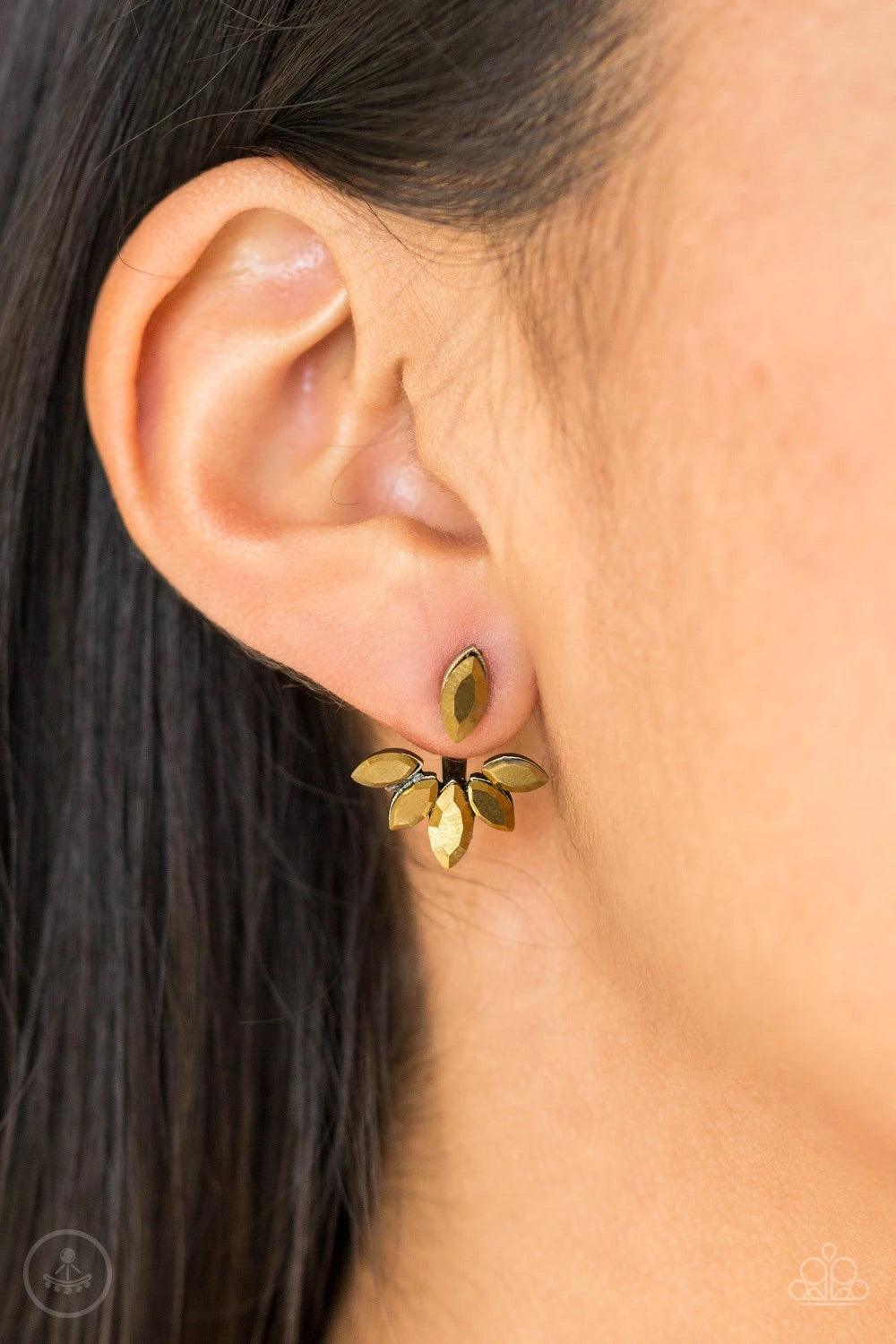 Paparazzi Accessories Radical Refinement - Brass A solitaire aurum marquise cut rhinestone attaches to a double-sided post, designed to fasten behind the ear. Encrusted in matching aurum rhinestones, a double-sided post peeks out beneath the ear, creating