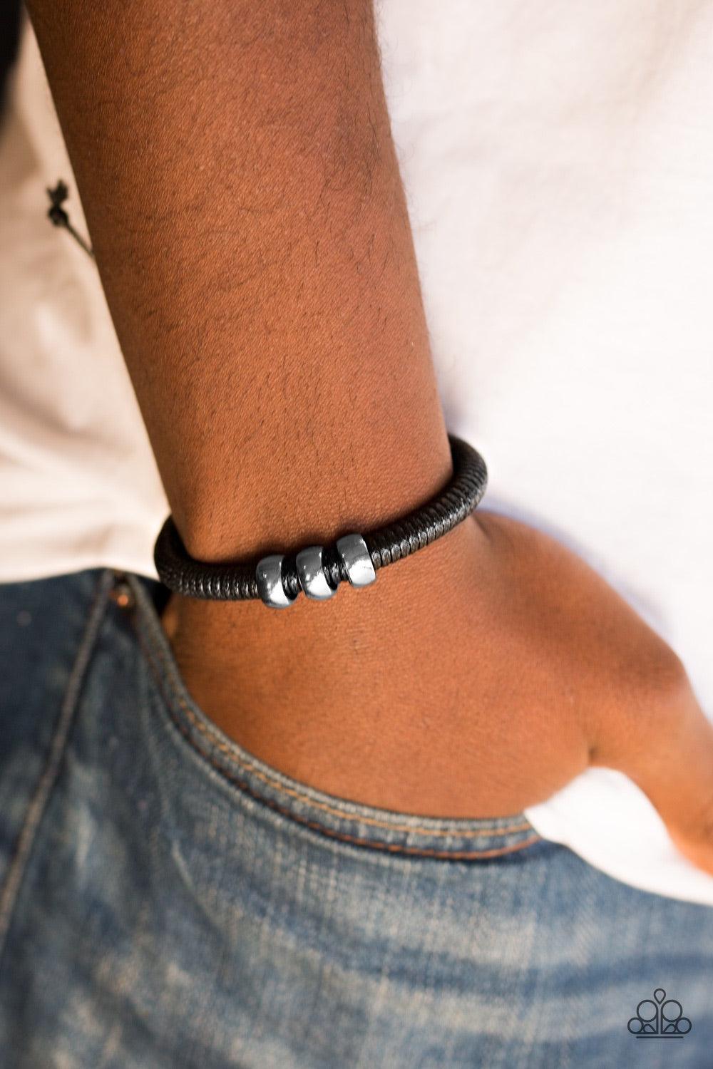 Paparazzi Accessories One For The Trail - Black Shiny black twine wraps around a black cord, creating an urban look around the wrist. Shiny silver beads slide along the cording for a rugged finish. Features an adjustable sliding knot closure. Jewelry