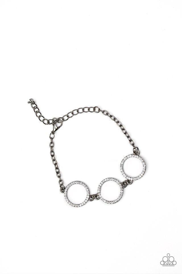 Paparazzi Accessories Dress The Part - Black Encrusted in glassy white rhinestones, three glittery gunmetal rings link across the wrist for a glamorous look. Features an adjustable clasp closure. Sold as one individual bracelet. Jewelry