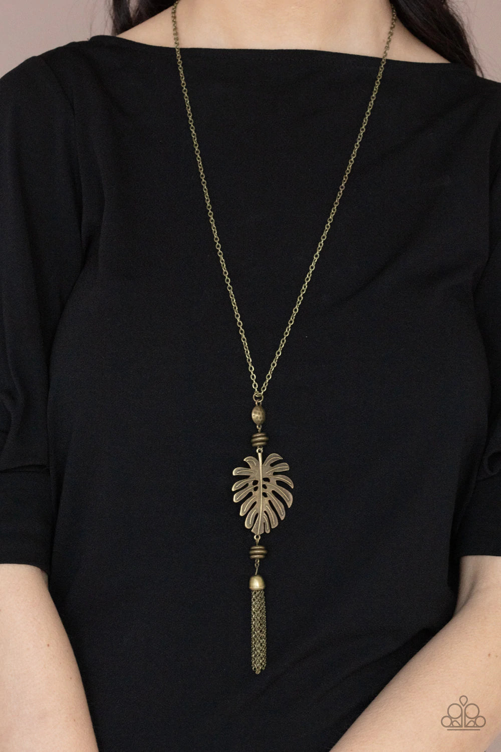 Paparazzi Accessories Palm Promenade - Brass Infused with brass beaded accents, a lifelike brass palm leaf frame attaches to the bottom of a rustic brass chain. An antiqued brass chain tassel swings from the bottom, adding flirtatious movement to the summ