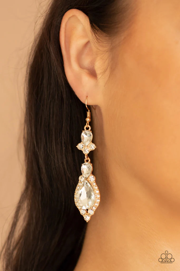 Paparazzi Accessories Fully Flauntable - Gold Encased in sleek gold frames, a sparkly series of round and teardrop white rhinestones flawlessly stack into a timelessly twinkly lure for a jaw-dropping look. Earring attaches to a standard fishhook fitting.