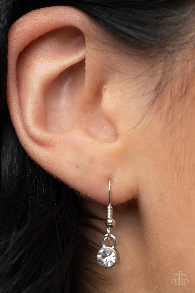 Paparazzi Accessories Envious Extravagance - Red An asymmetrical red gem is pressed into a shiny silver frame dusted in glassy white rhinestones, resulting in a refined pendant at the bottom of a dainty silver chain. Features an adjustable clasp closure.