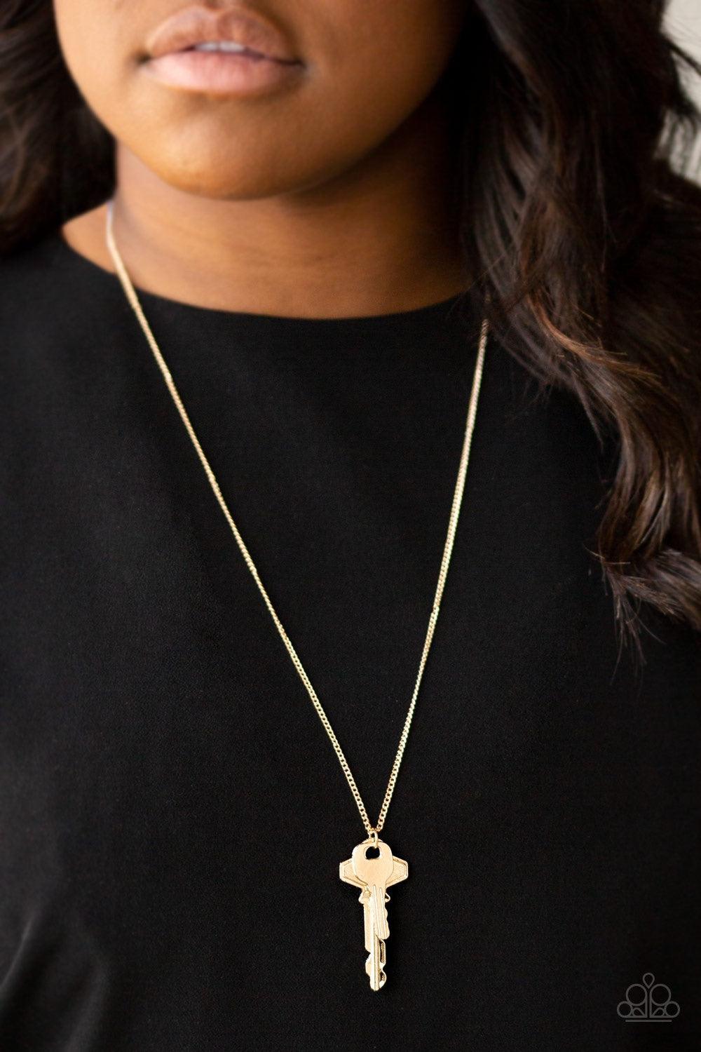 Paparazzi Accessories The Keynoter - Gold A mismatched pair of gold keys swing from the bottom of a shimmery gold chain, creating an edgy pendant. Features an adjustable clasp closure. Jewelry
