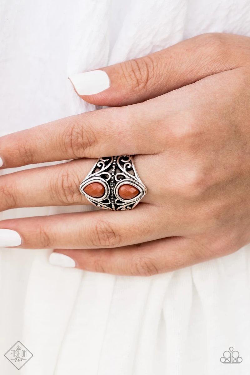 Paparazzi Accessories Rural Revel - Brown Two back-to-back Cinnamon Stick teardrop beads sit atop a stacked band of silver filigree, creating a whimsical centerpiece atop the finger. Features a stretchy band for a flexible fit. Sold as one individual ring