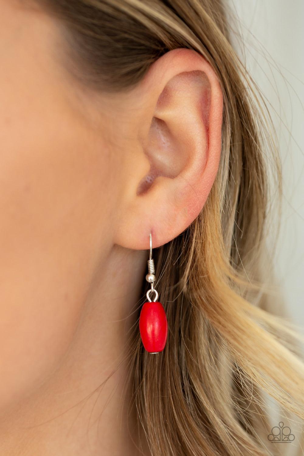 Paparazzi Accessories Explore The Elements - Red A collection of shiny silver beads and fiery red stone beads are threaded along an invisible wire below the collar. A dramatically oversized red stone teardrop pendant swings from the bottom of a seasonal f