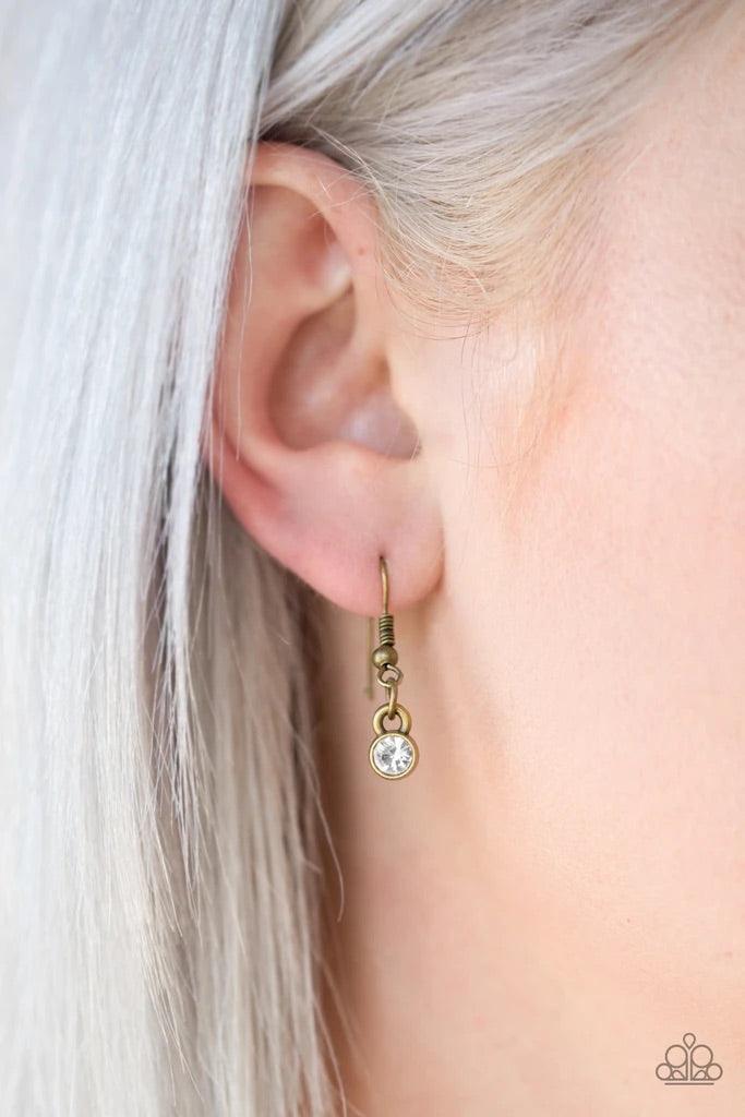 Paparazzi Accessories The Imperfectionist - Brass Featuring antiqued brass frames, imperfect glassy white gems link below the collar for a glamorous vintage inspired look. Features an adjustable clasp closure. Sold as one individual necklace. Includes one