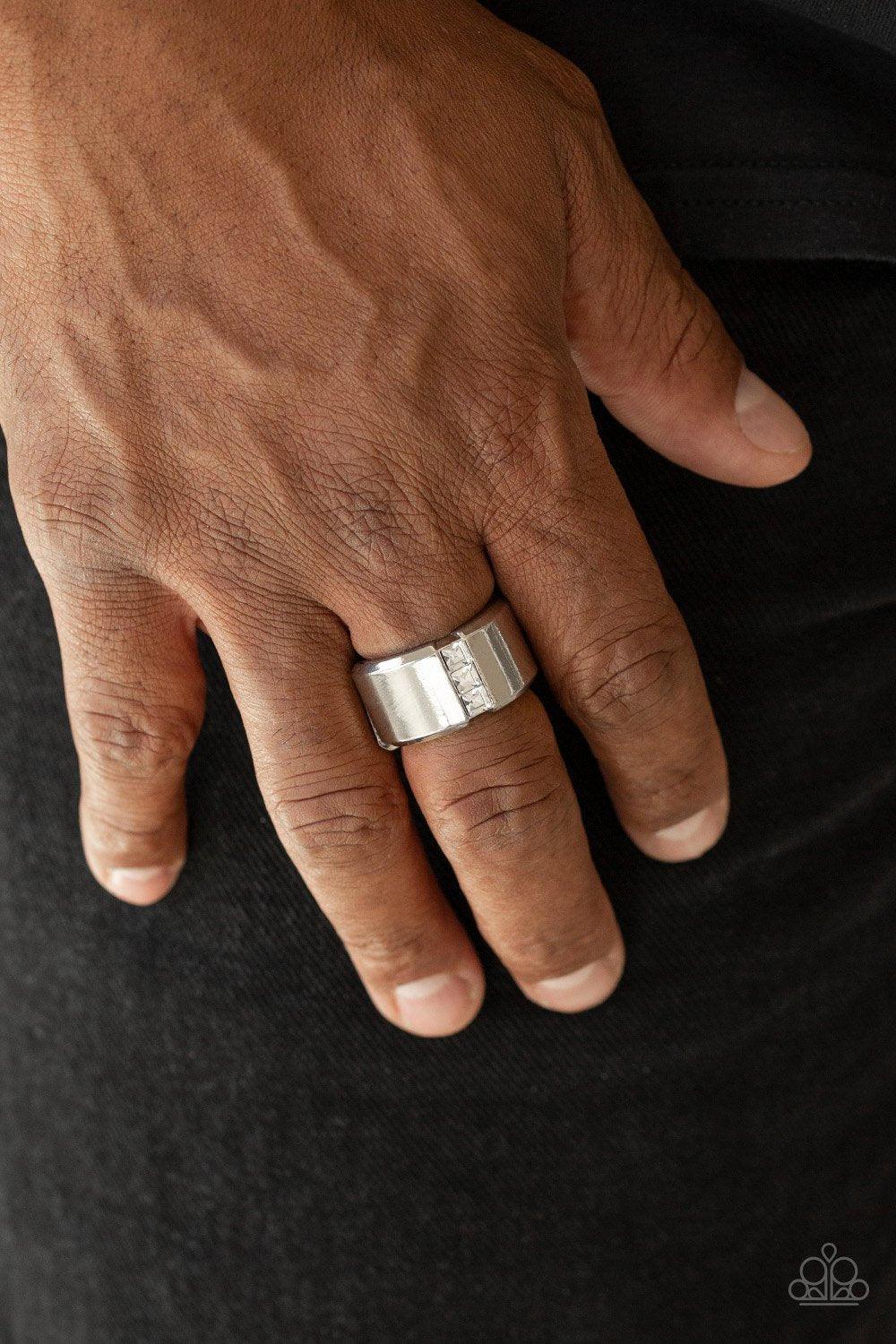 Paparazzi Accessories The Graduate - White A single row of square-cut white rhinestones stack down the center of a thick silver band. Features a stretchy band for a flexible fit. Sold as one individual ring. Rings