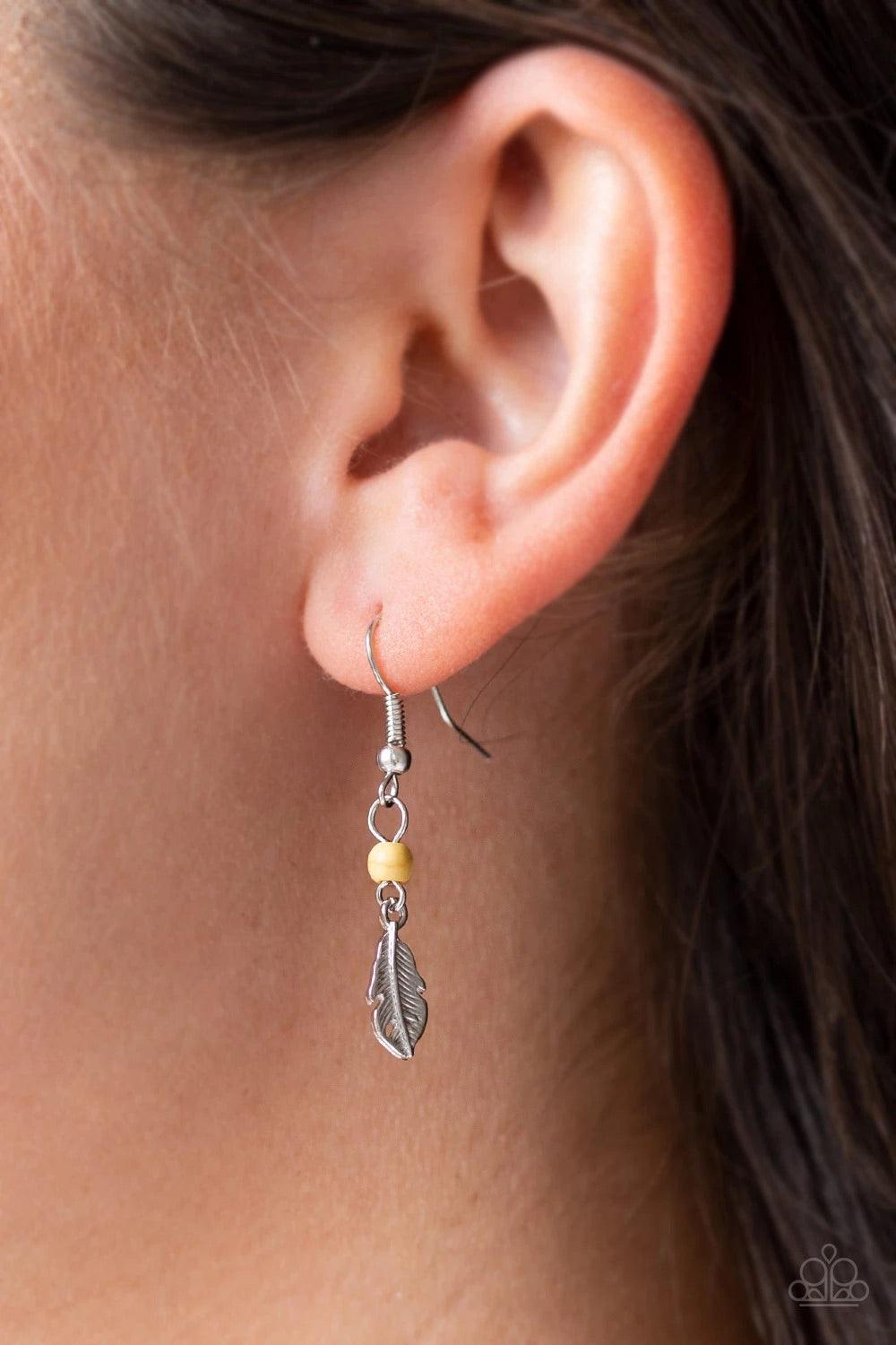 Paparazzi Accessories On The Fly - Yellow Attached to a lengthened silver chain, a hammered silver bar gives way to a fringe of shimmery silver chain, yellow stone beads, and silver feather frames for a seasonal look. Features an adjustable clasp closure.