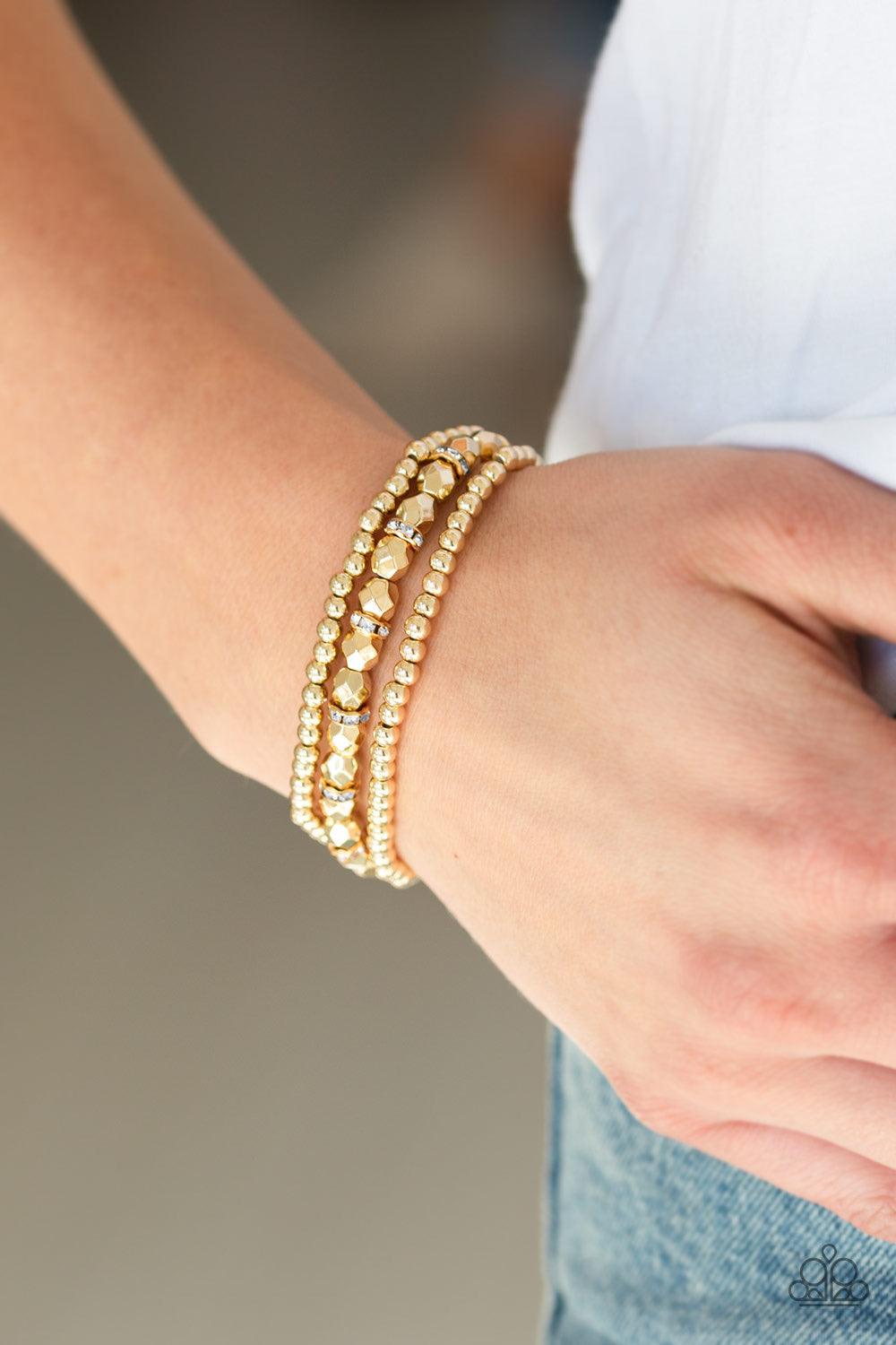 Paparazzi Accessories Let There BEAM Light - Gold Infused with white rhinestone encrusted rings, mismatched dainty silver and faceted gold beads are threaded along stretchy bands for a refined look. Jewelry