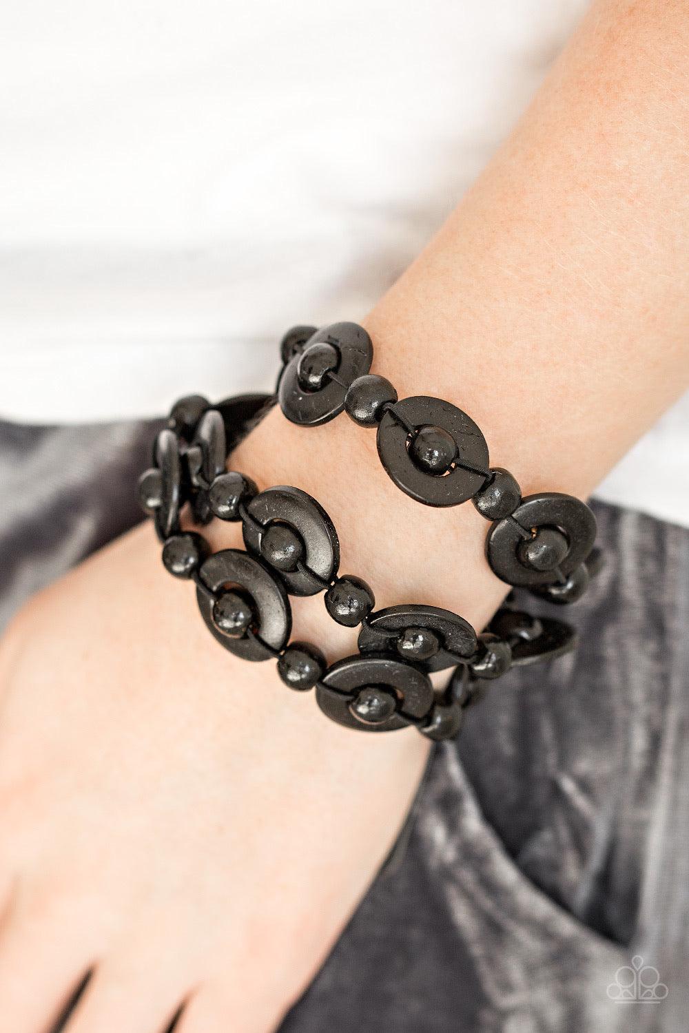 Paparazzi Accessories Cancun Catch ~Black Brushed in distressed black finishes, wooden rings and beads are knotted in place along three stretchy strands, creating summery layers around the wrist. Features a button loop closure. Sold as one individual brac