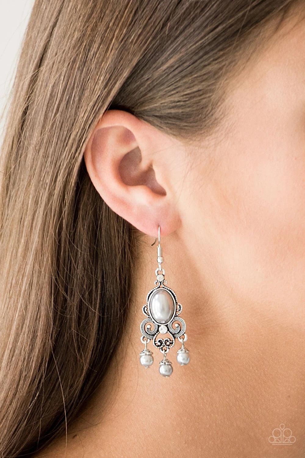 Paparazzi Accessories I Better Get GLOWING - Silver Dotted silver filigree spins around a pearly silver bead and dainty white rhinestones, coalescing into a regal frame. A pearly fringe swings from the bottom of the frame for a refined finish. Earring att